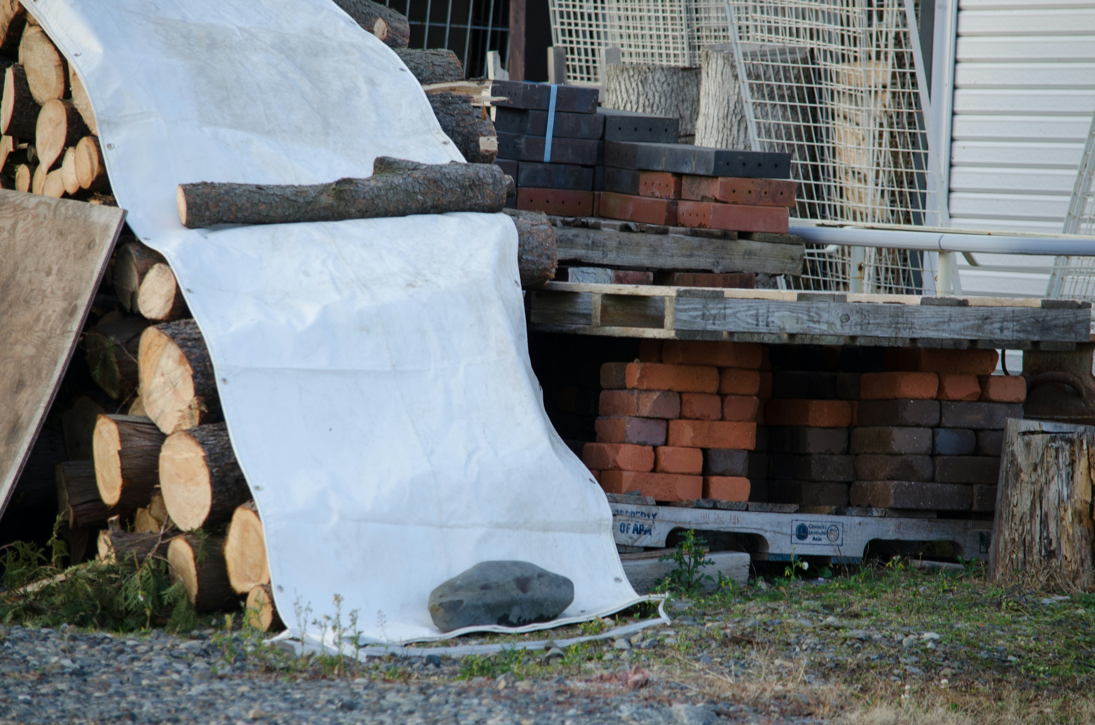 Landscape with stacked wood and bricks featuring a white sheet