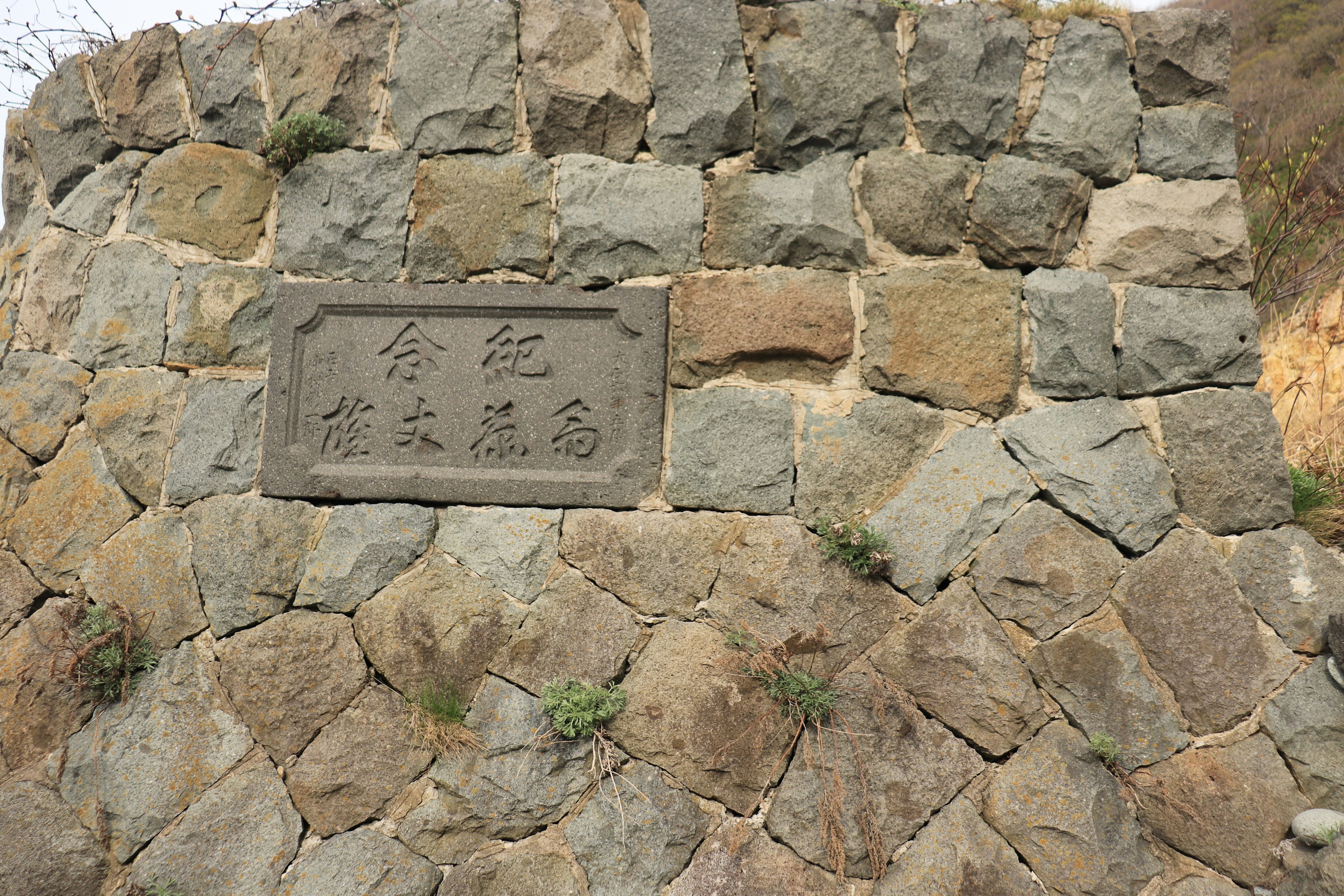 Una placa montada en una pared de piedra con inscripciones