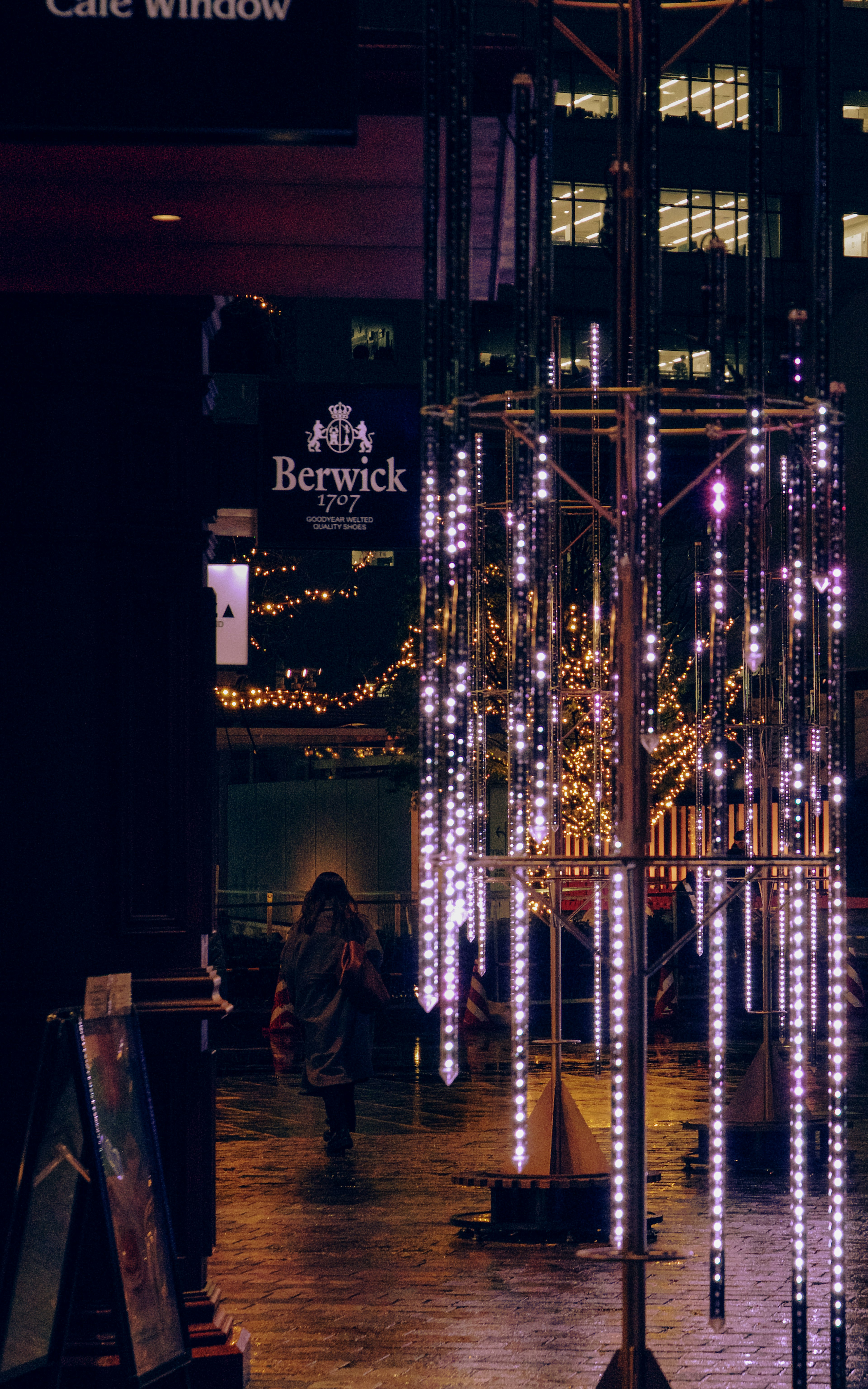 Columna decorativa con luces LED brillantes en un paisaje urbano nocturno