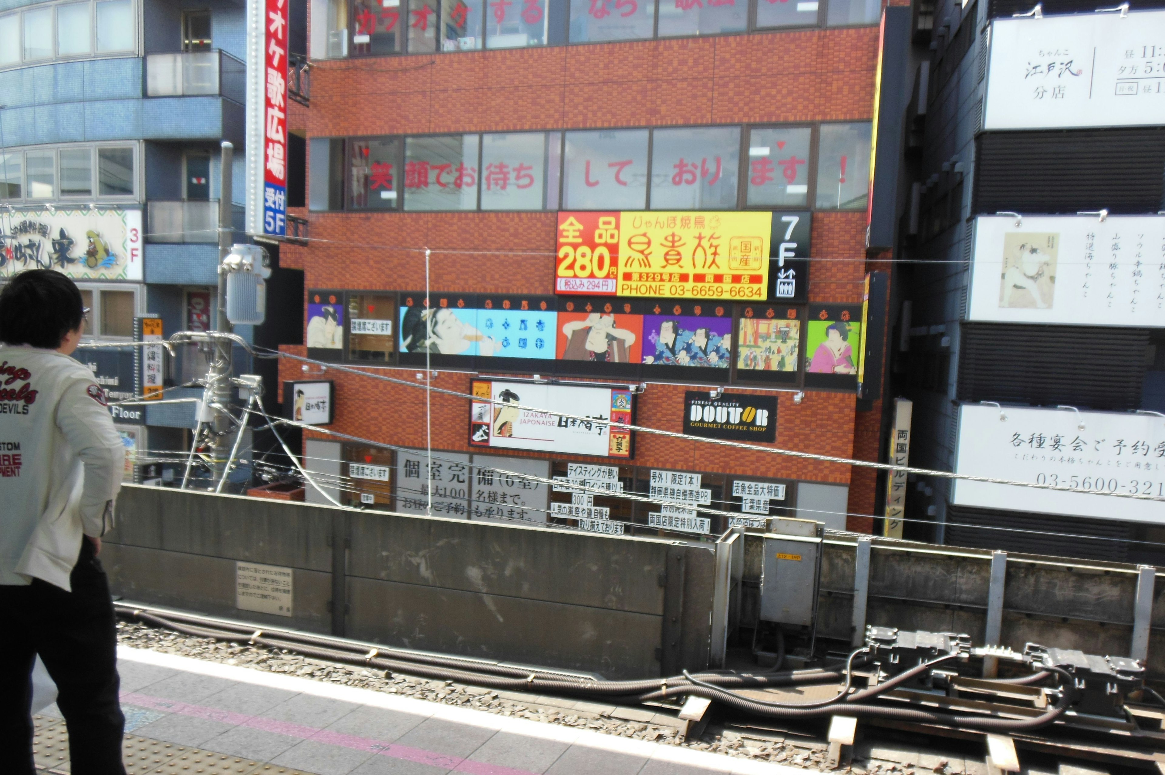 駅のプラットフォームから見えるビル群と看板