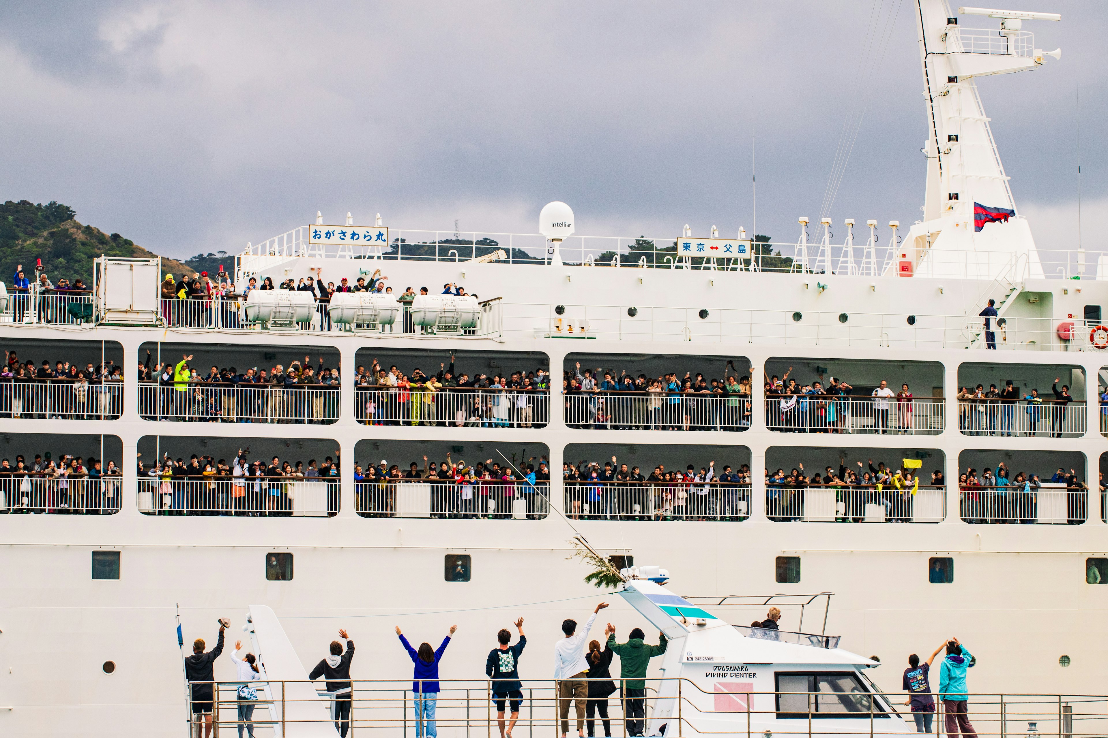 Cruise ship passengers waving from the deck many people visible