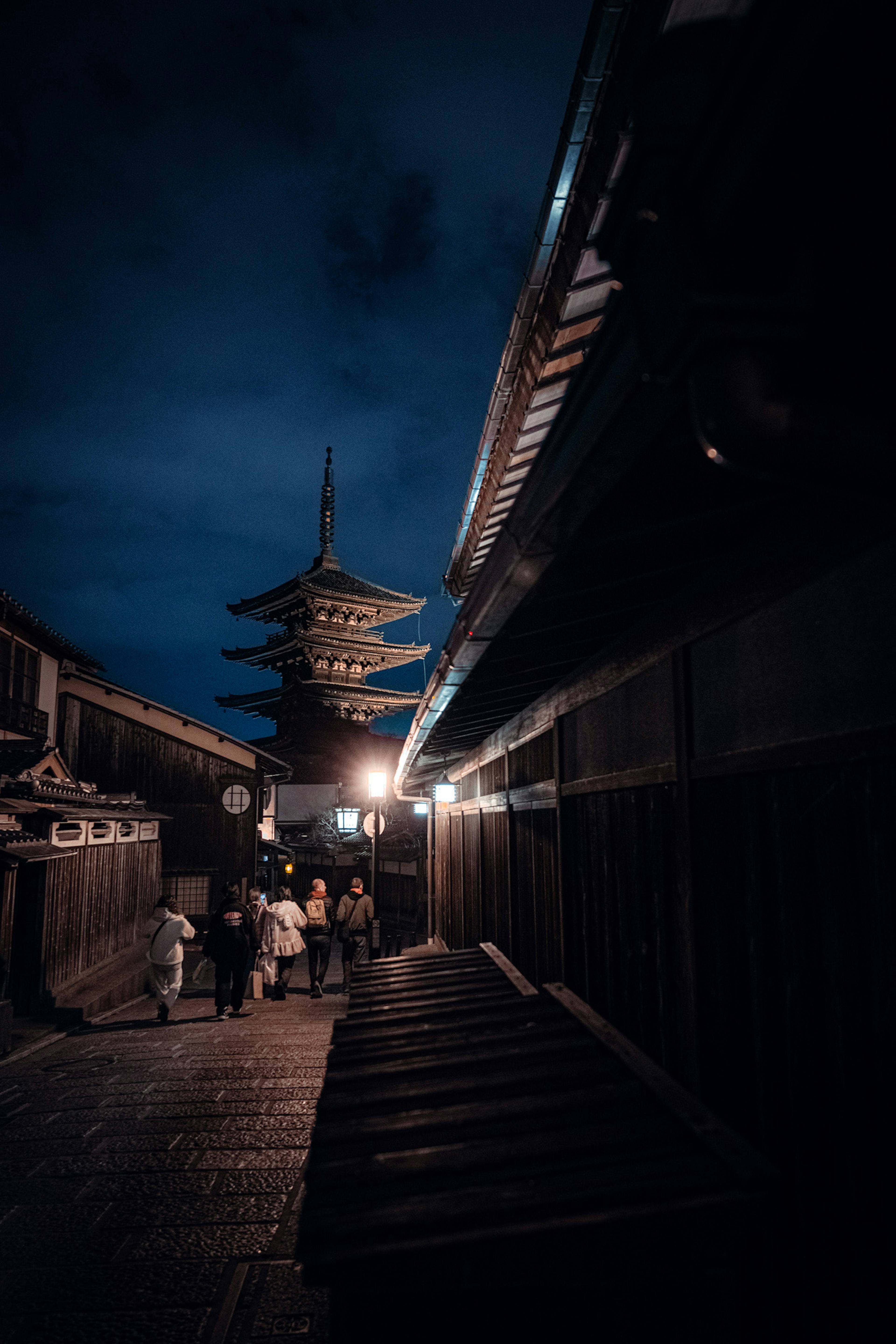 夜の京都の街並みに立つ五重塔と古い建物