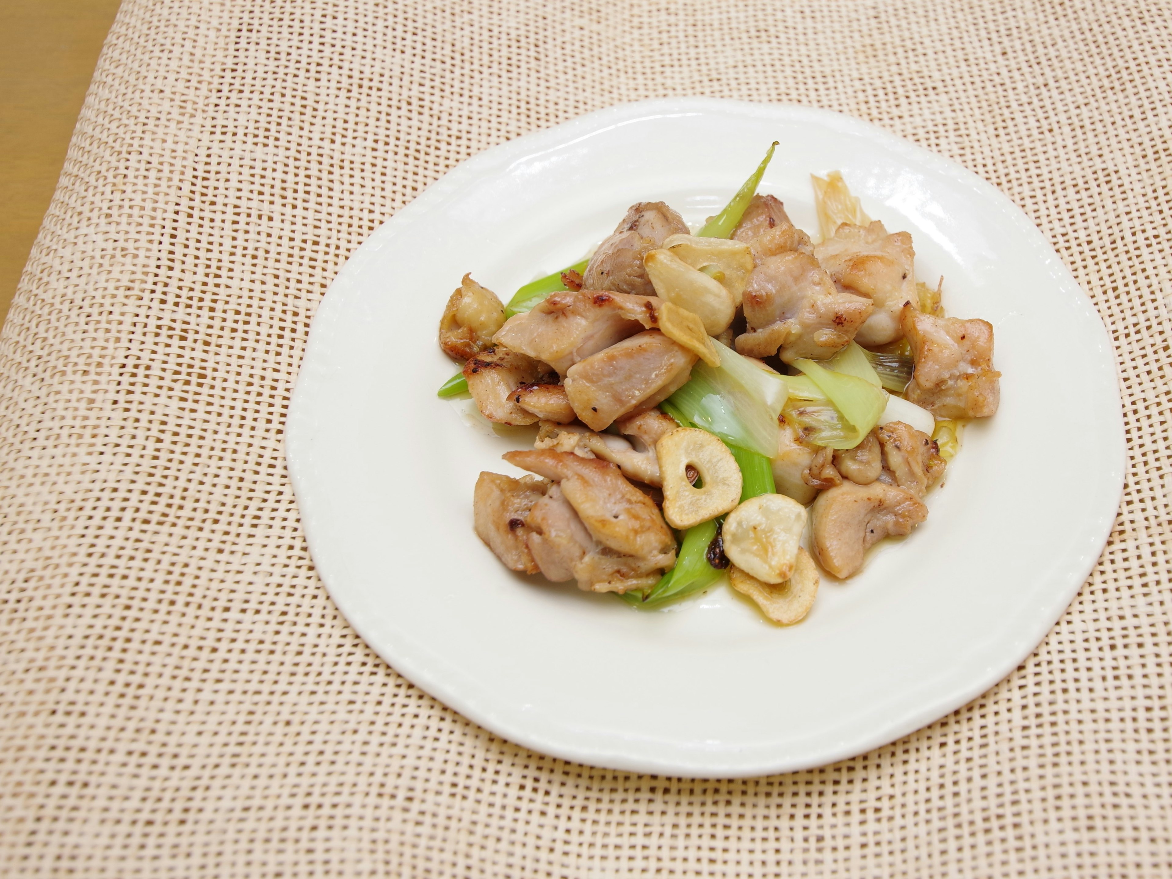 Pollo salteado con verduras en un plato blanco