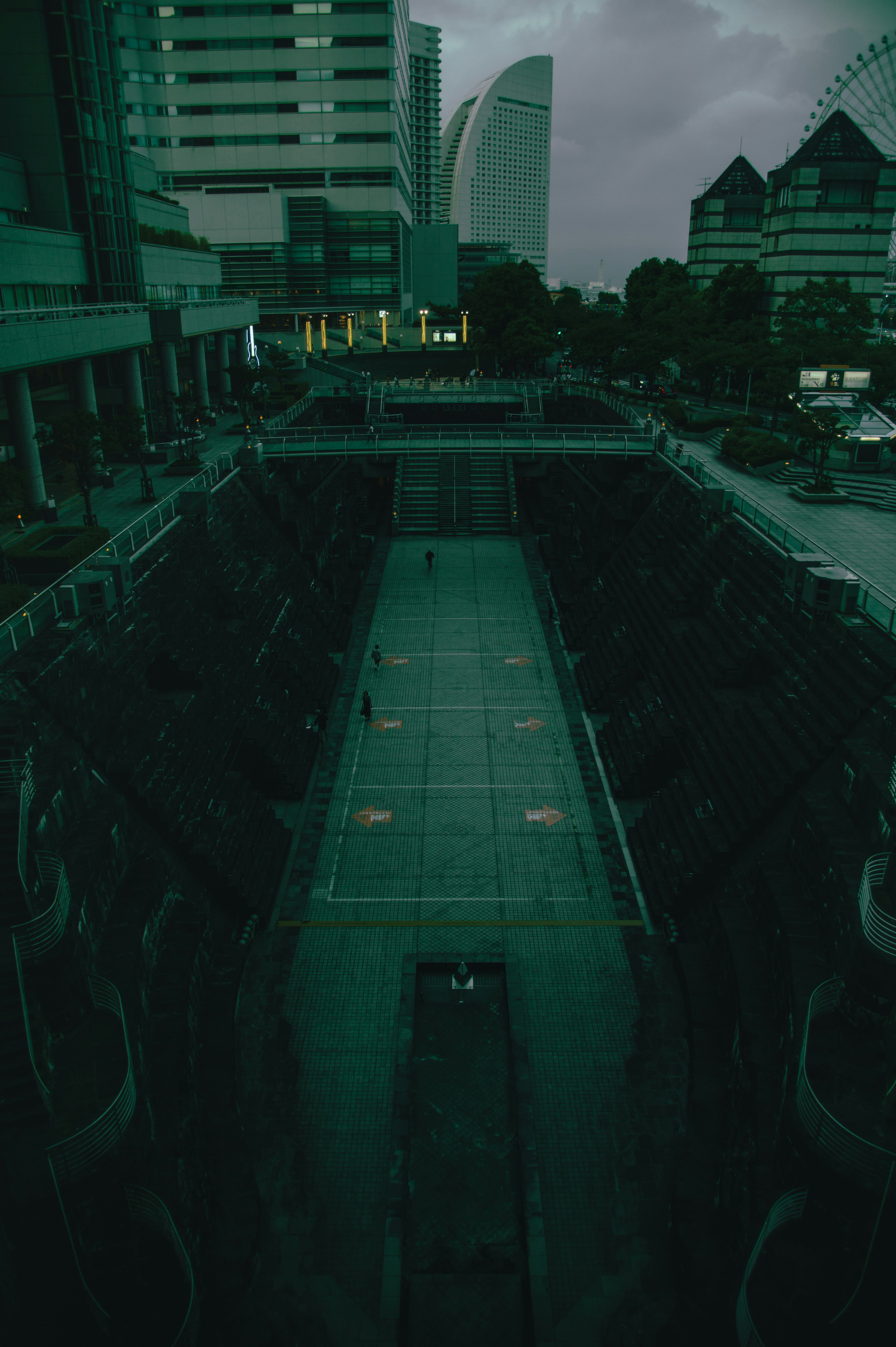 Aerial view of a dark tennis court surrounded by buildings