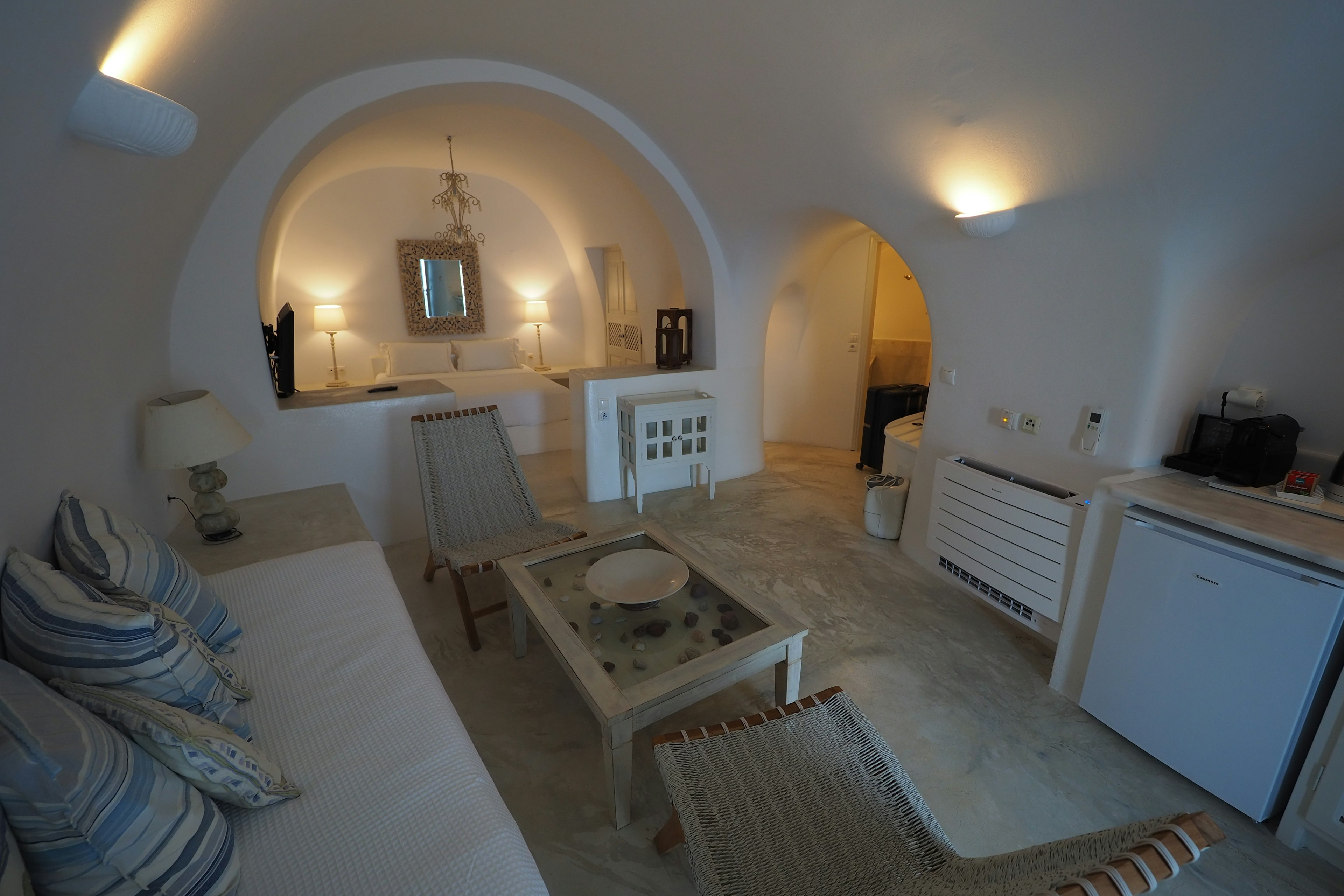 Modern living room with white walls and arched ceiling featuring a sofa and wooden table