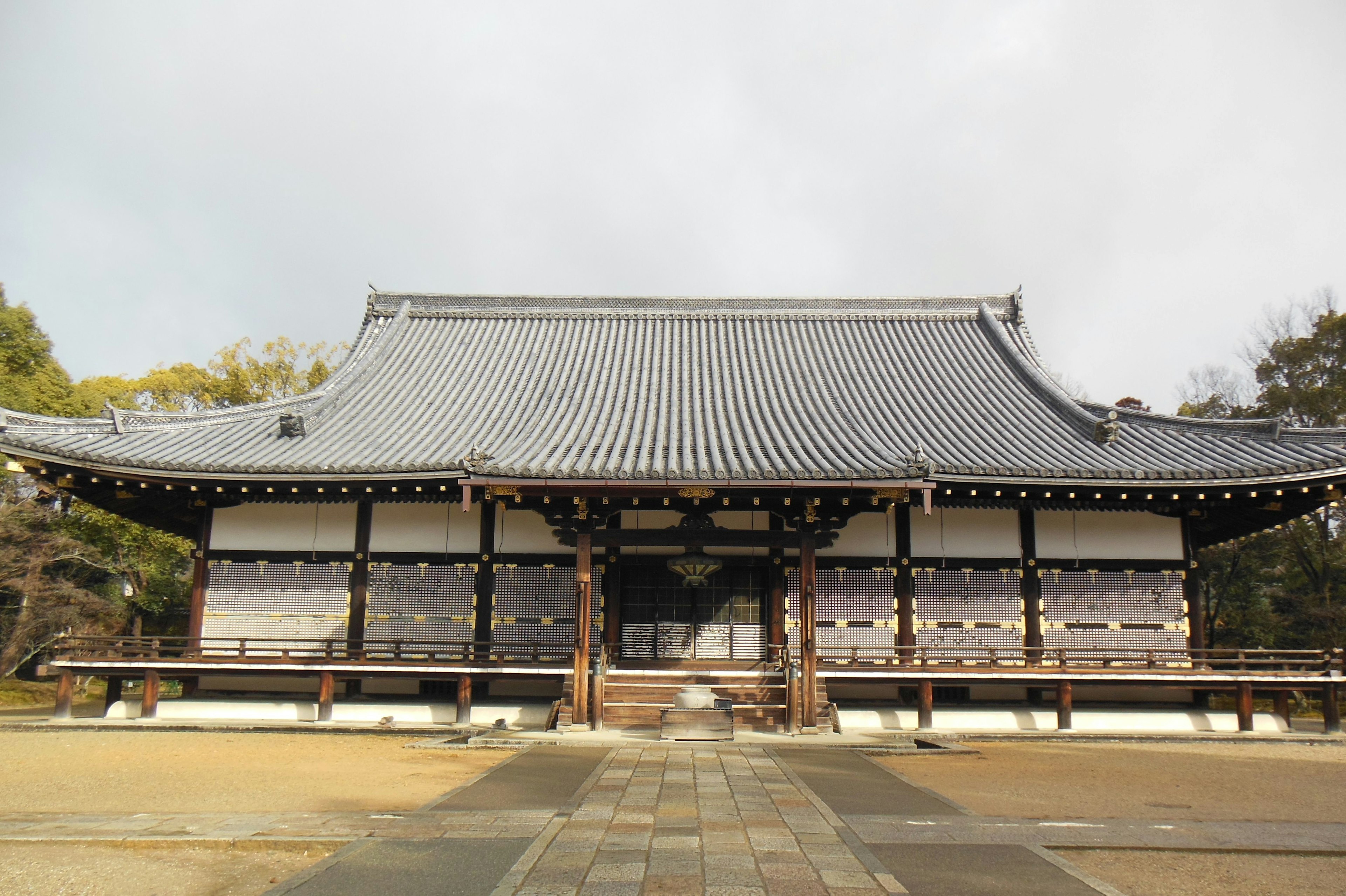 Traditional Japanese temple exterior featuring tiled roof and wooden pillars