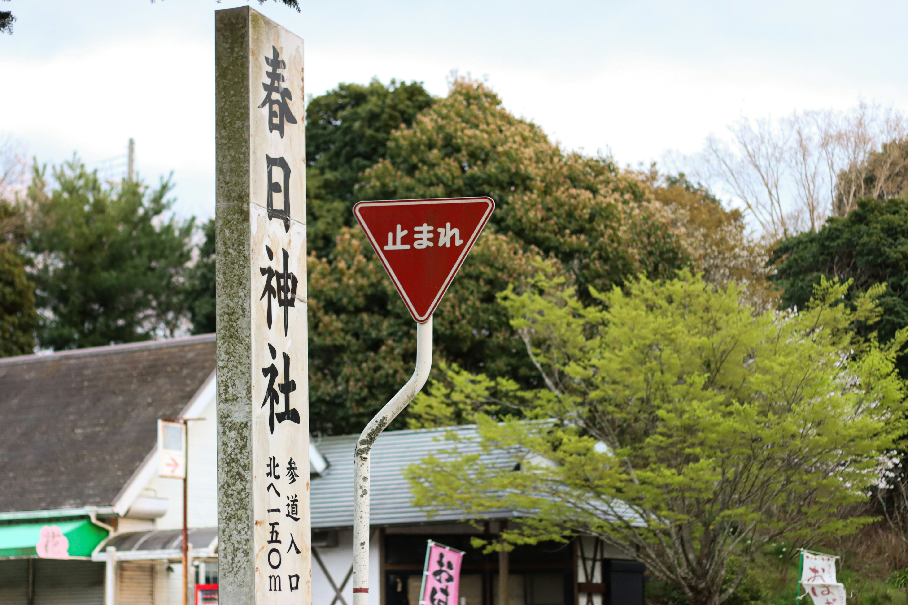 春日神社の看板と止まれの標識が見える風景