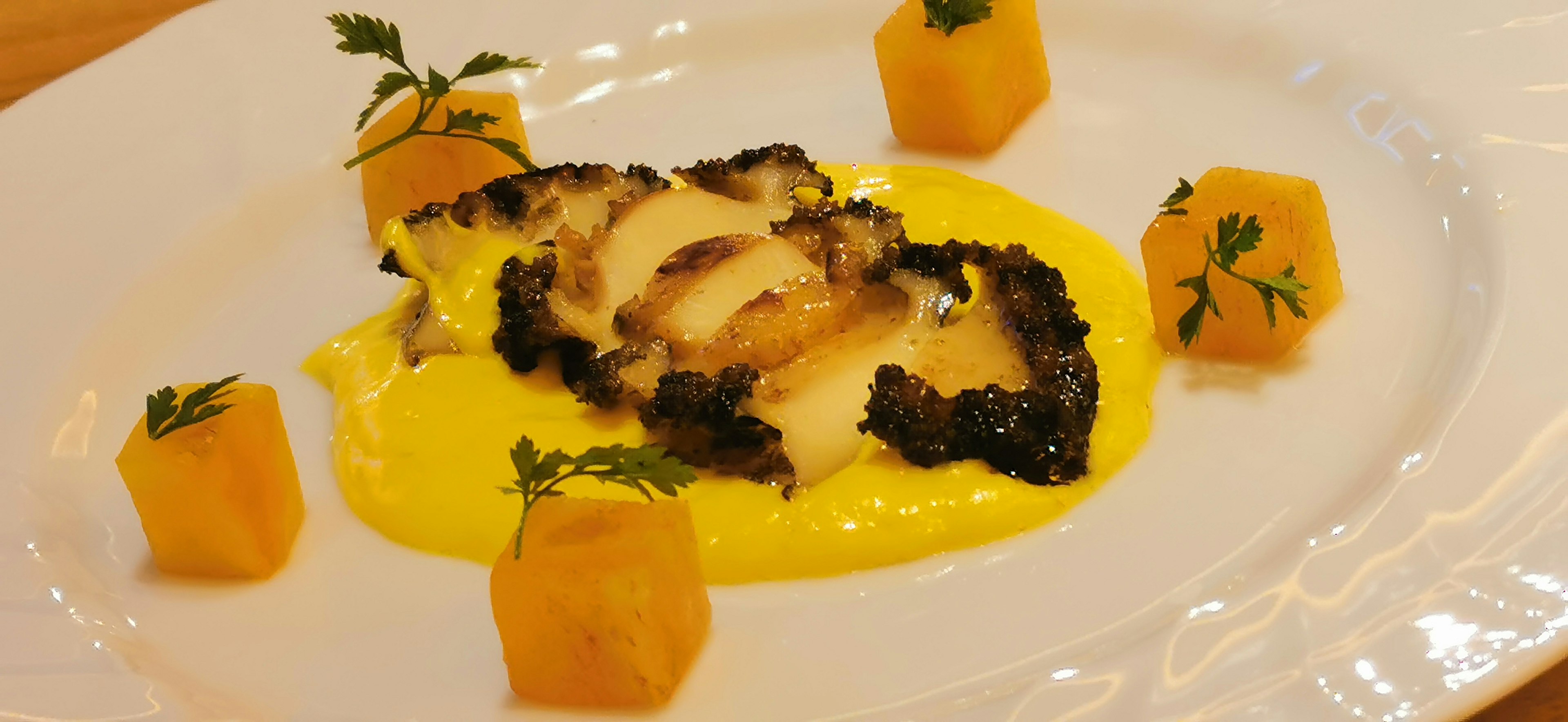 Pesce grigliato con salsa cremosa servito con cubetti di zucca