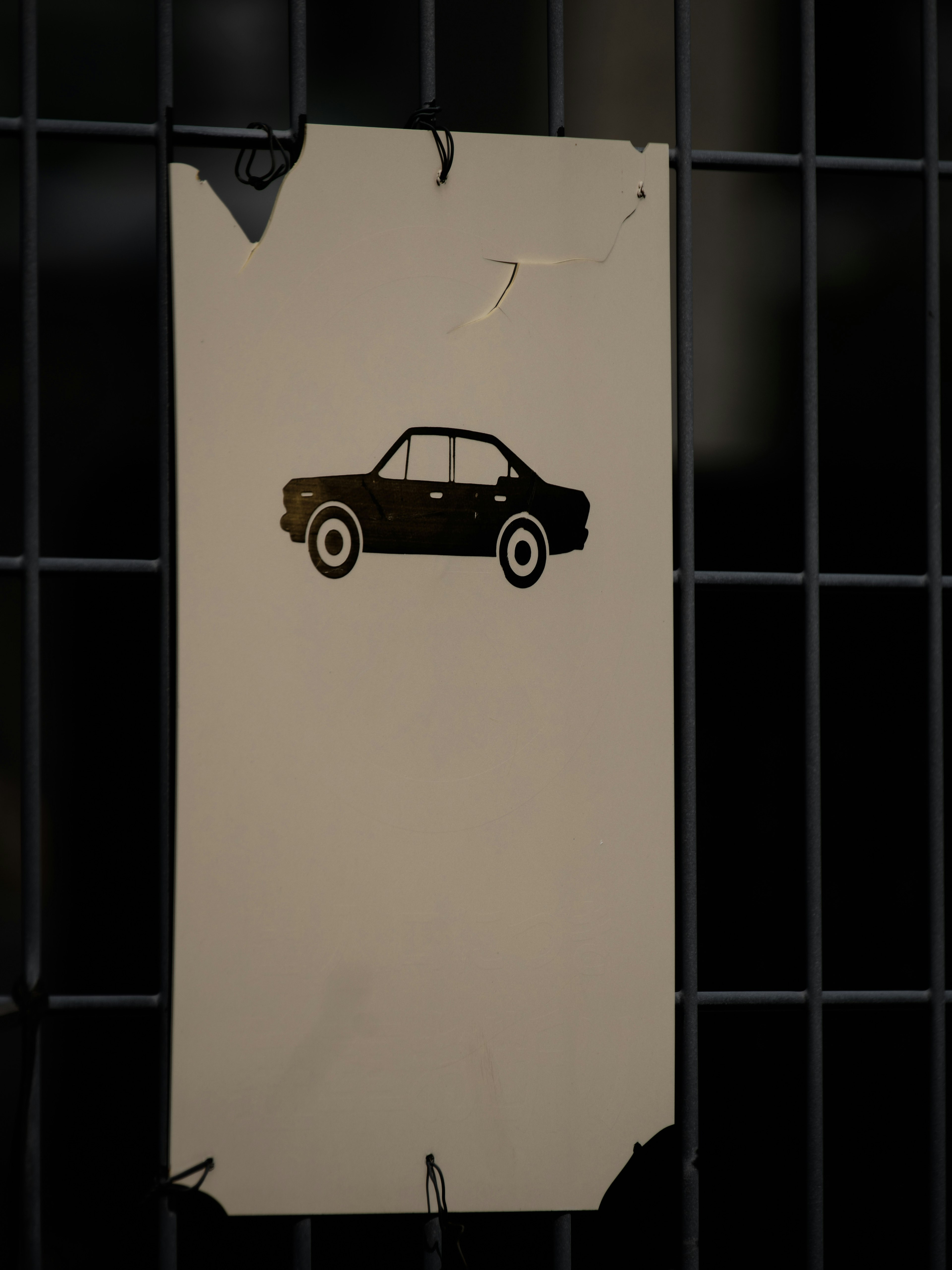 An old sign featuring a silhouette of a black car