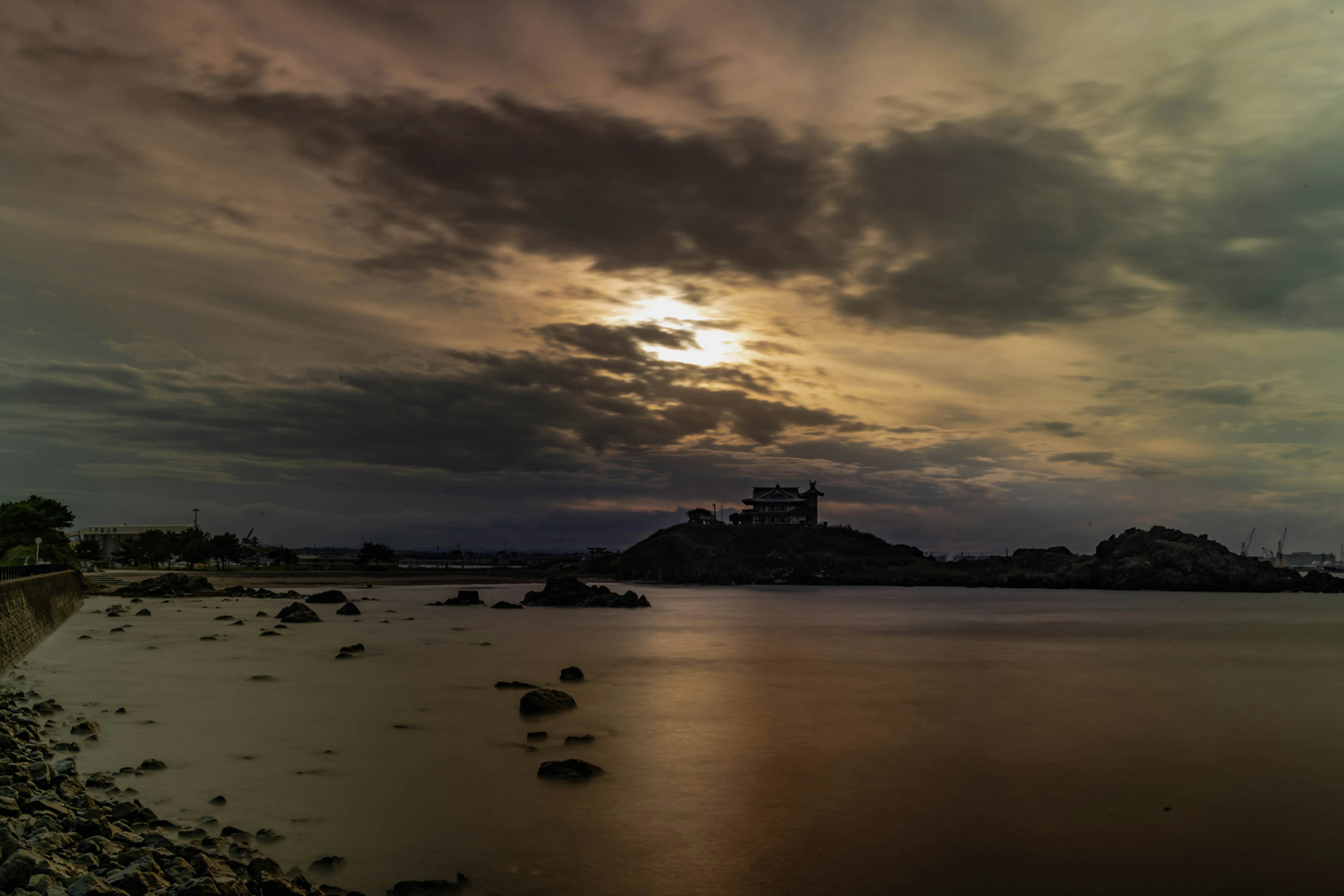 Paysage aquatique serein avec un coucher de soleil et des nuages superposés