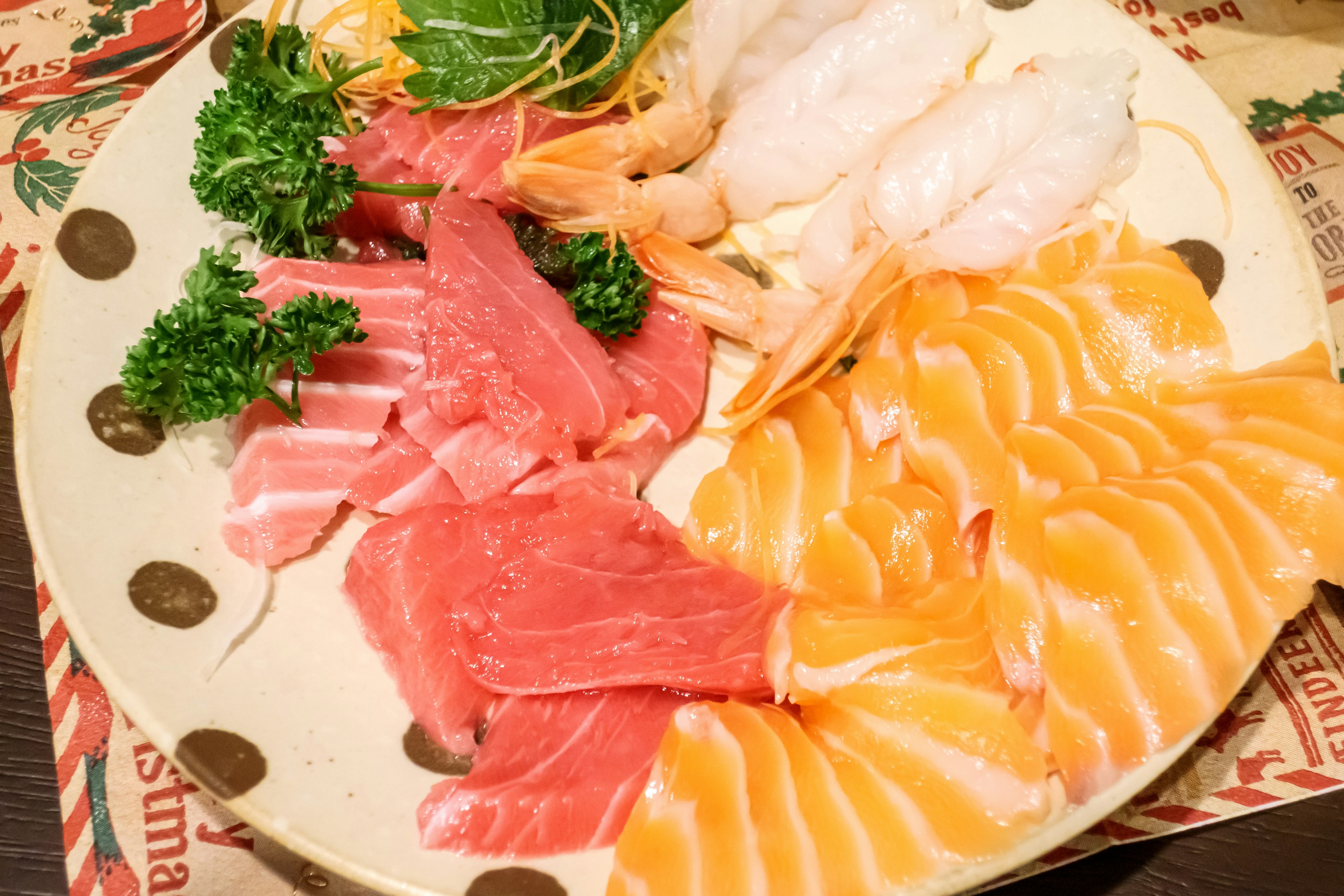 Fresh sashimi platter featuring salmon, tuna, shrimp, and parsley arrangement