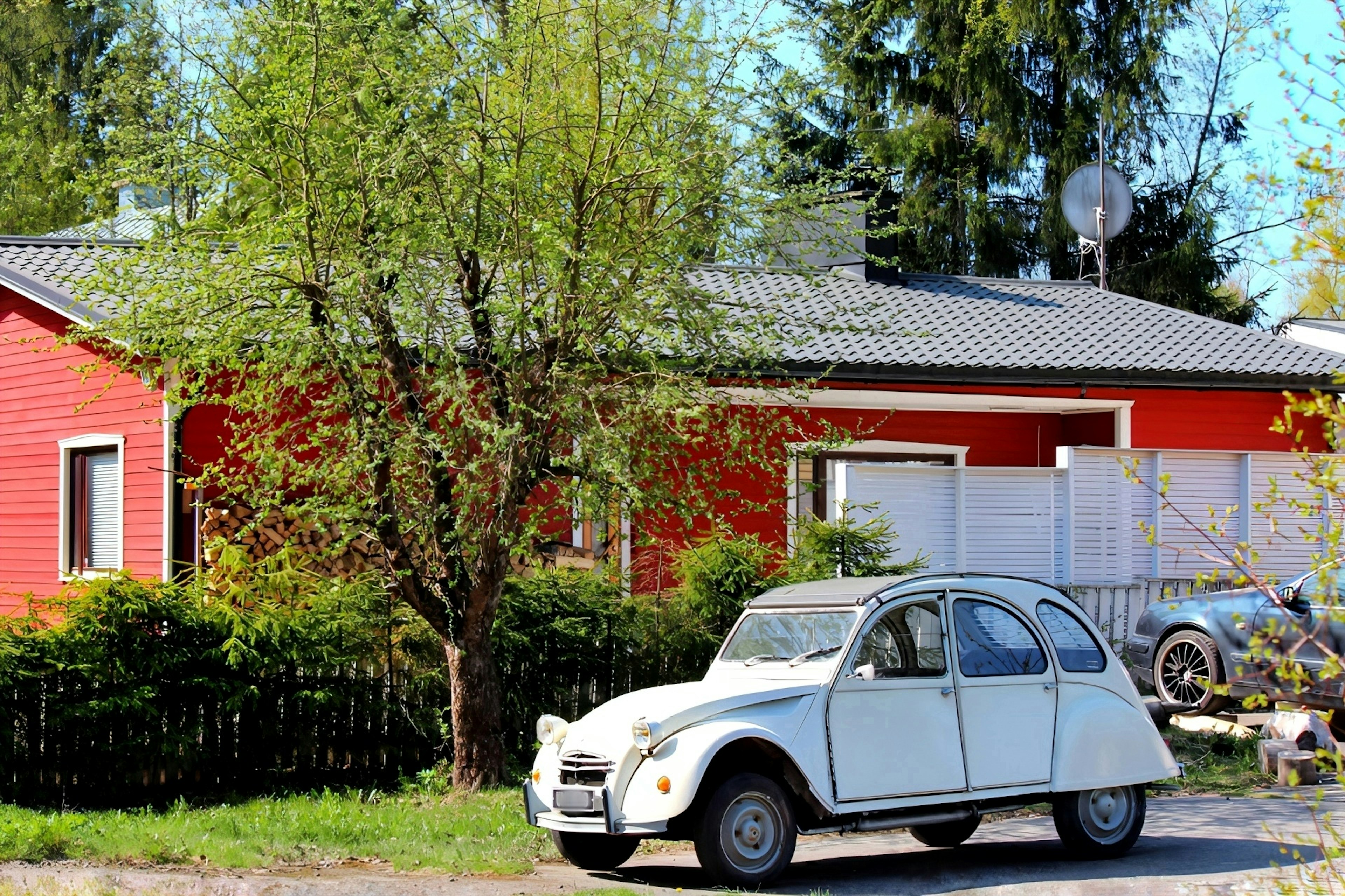 A red house with a white car parked in front