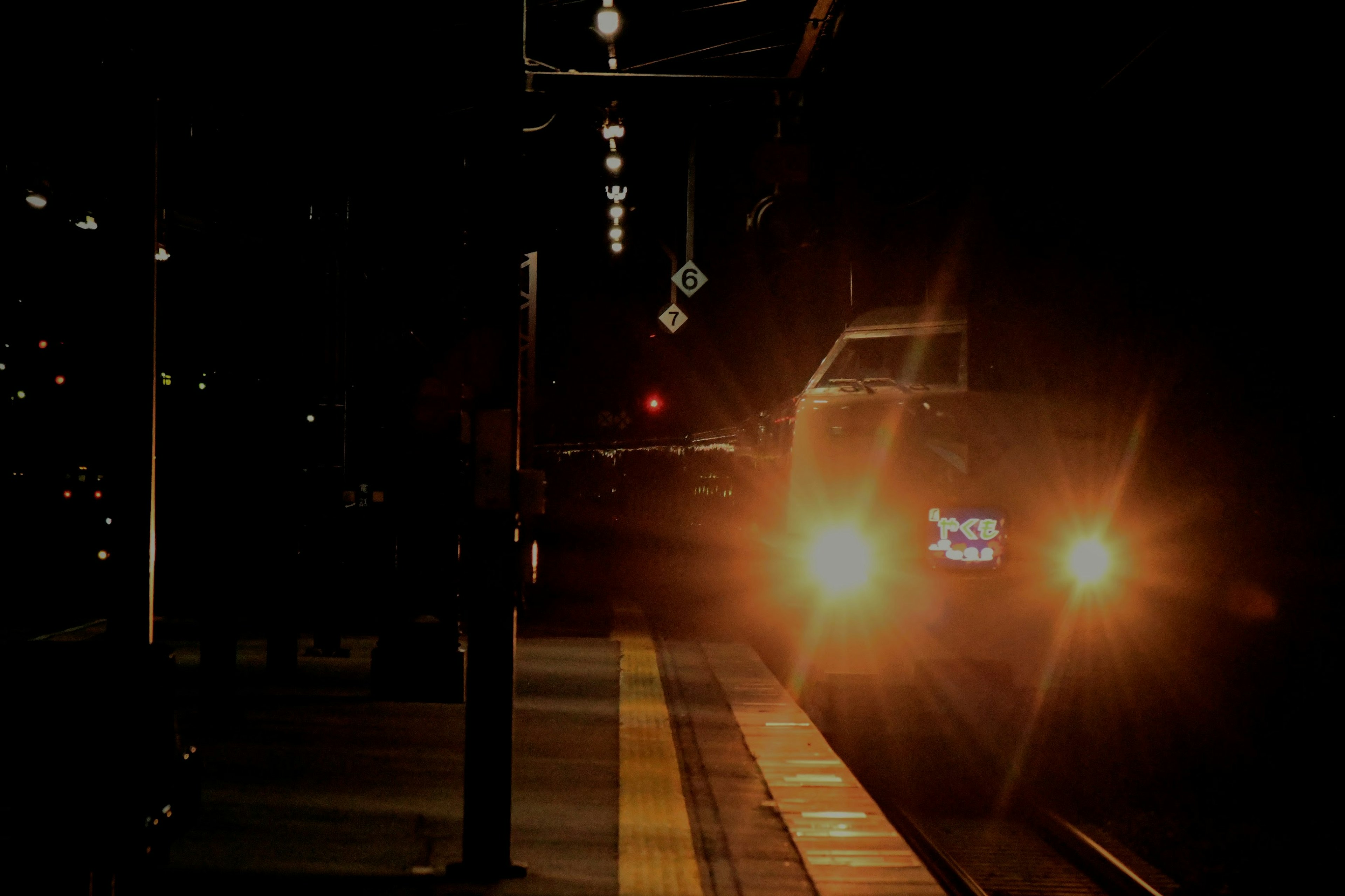 Treno con fari luminosi in una stazione notturna