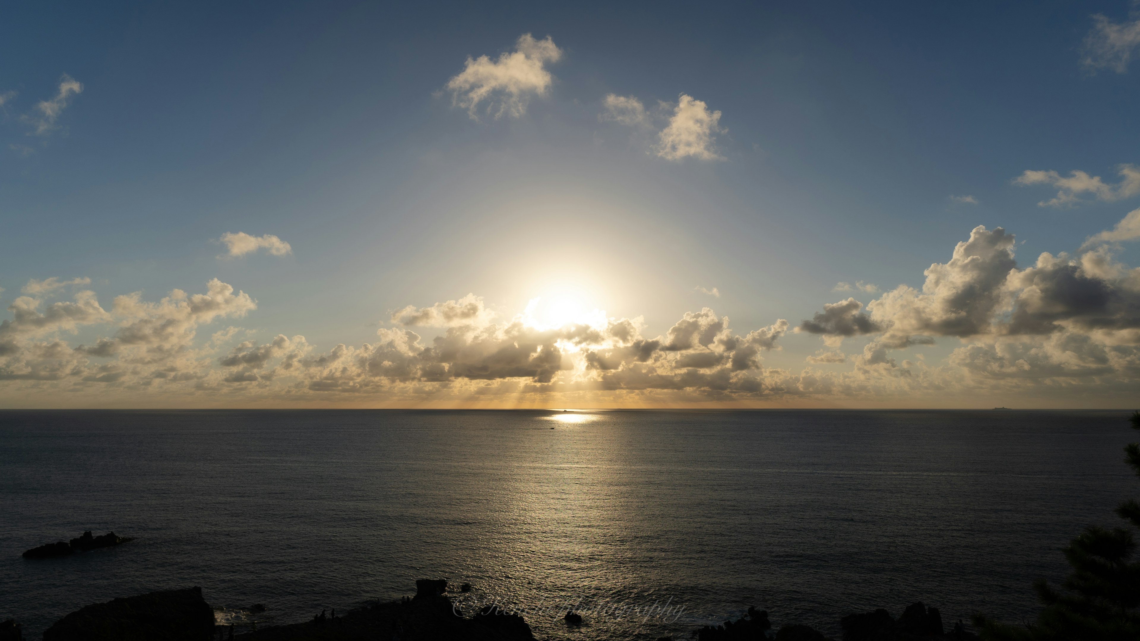 Beautiful landscape with the sun setting over the ocean and clouds