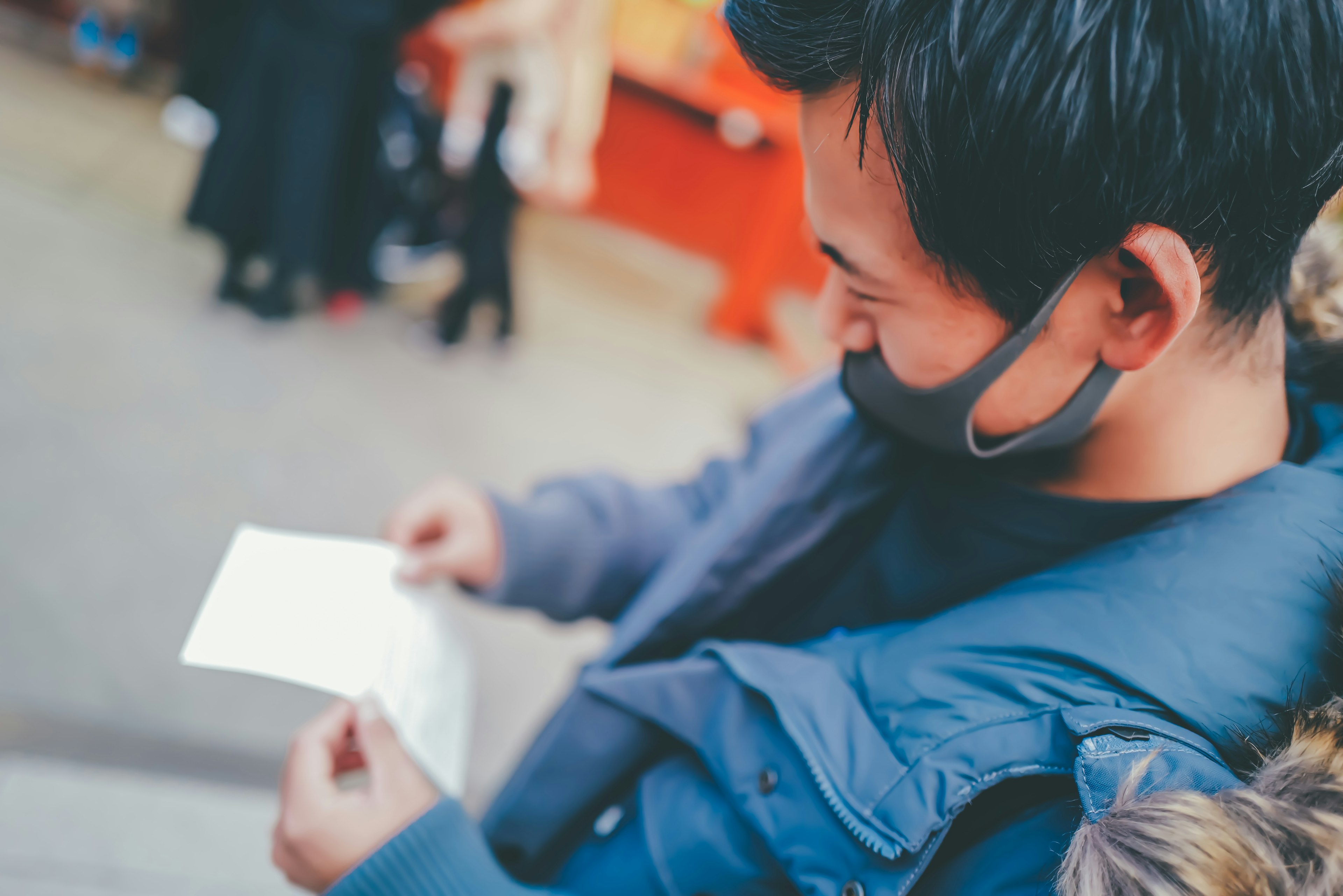 Man wearing a mask looking at a white piece of paper