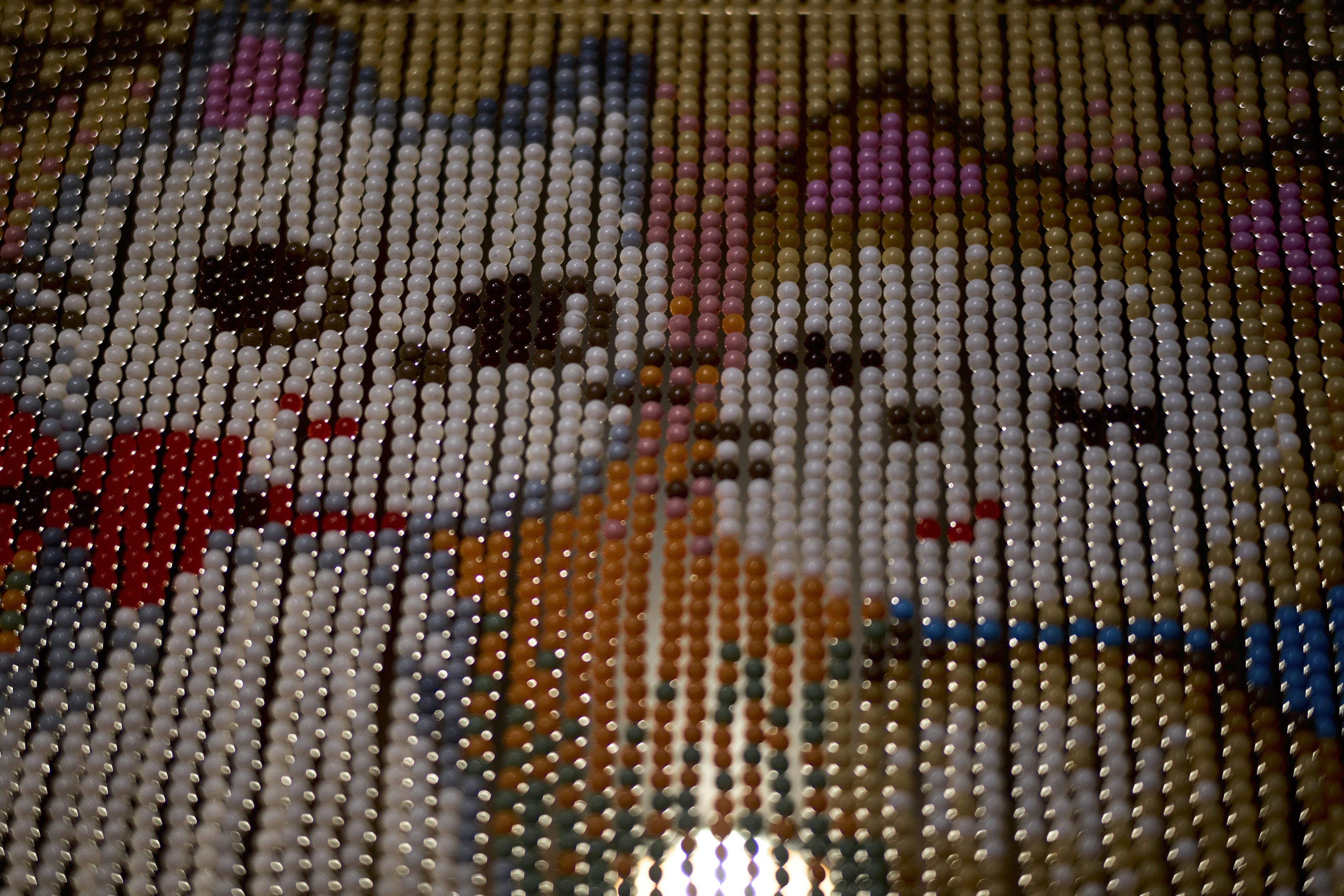 Beaded art featuring two cartoon cats with expressive faces