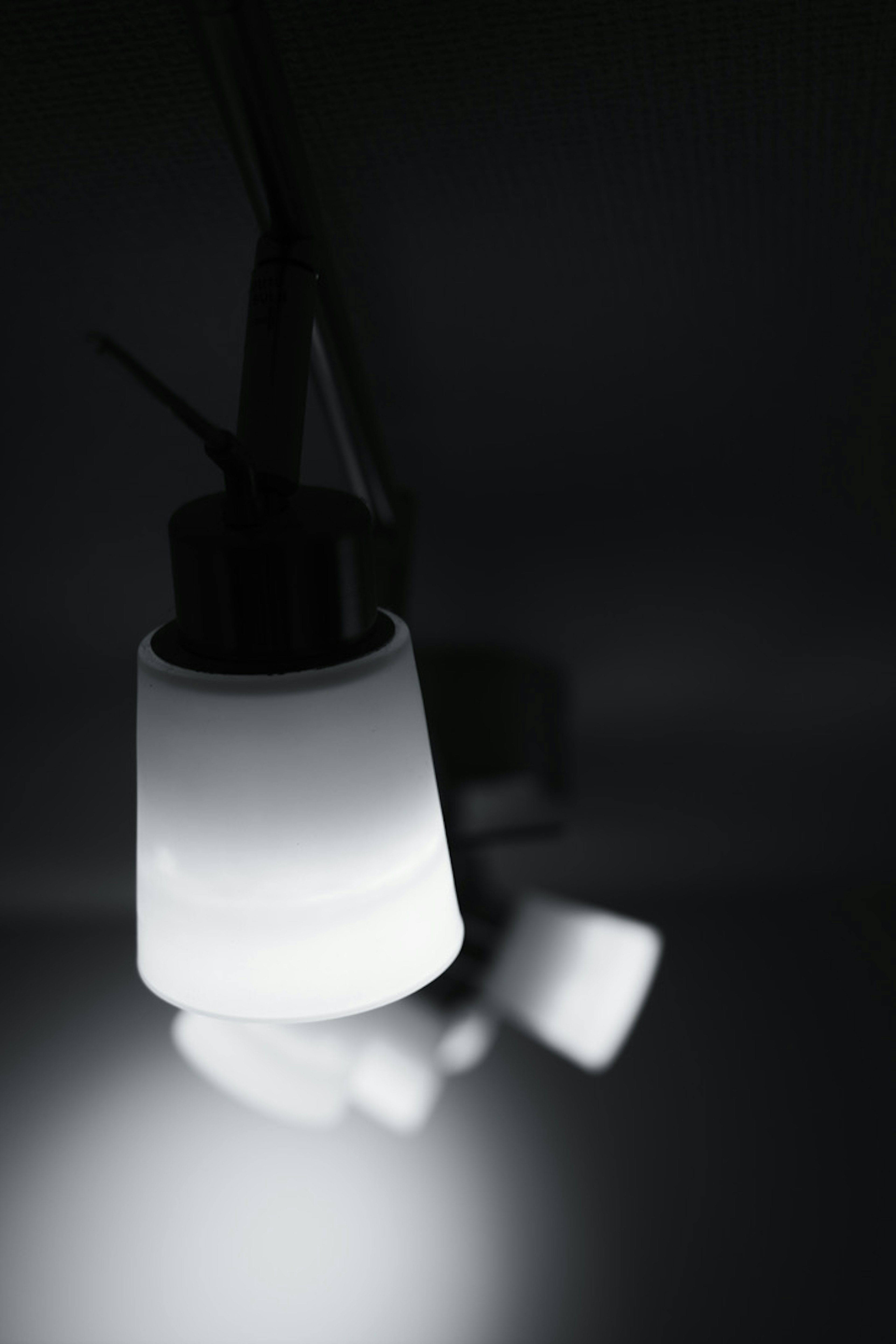 White light fixtures hanging against a dark background