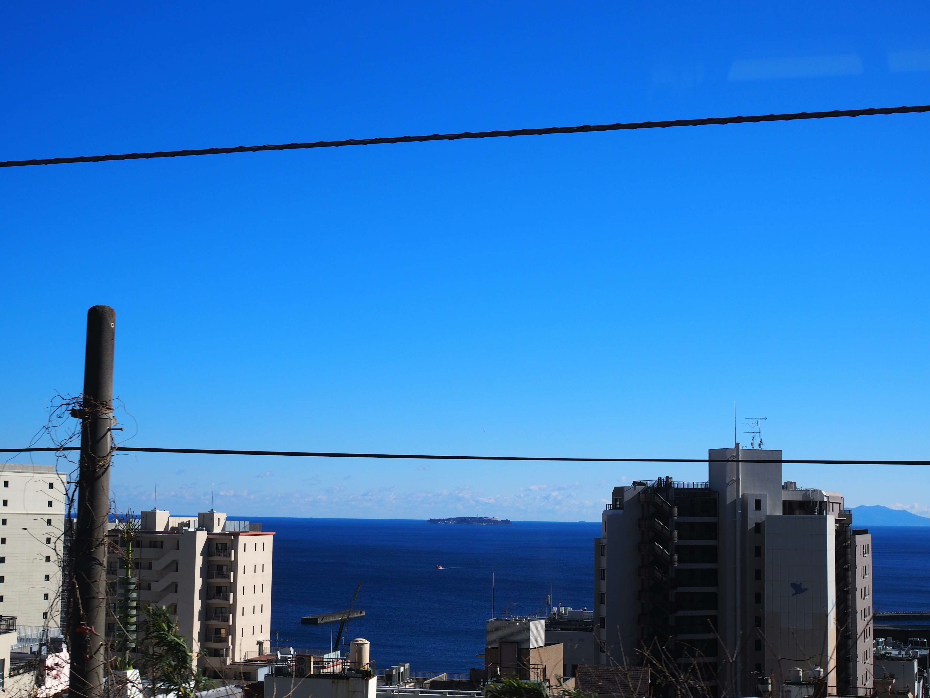 青い空と海を背景にした都市の景観画像