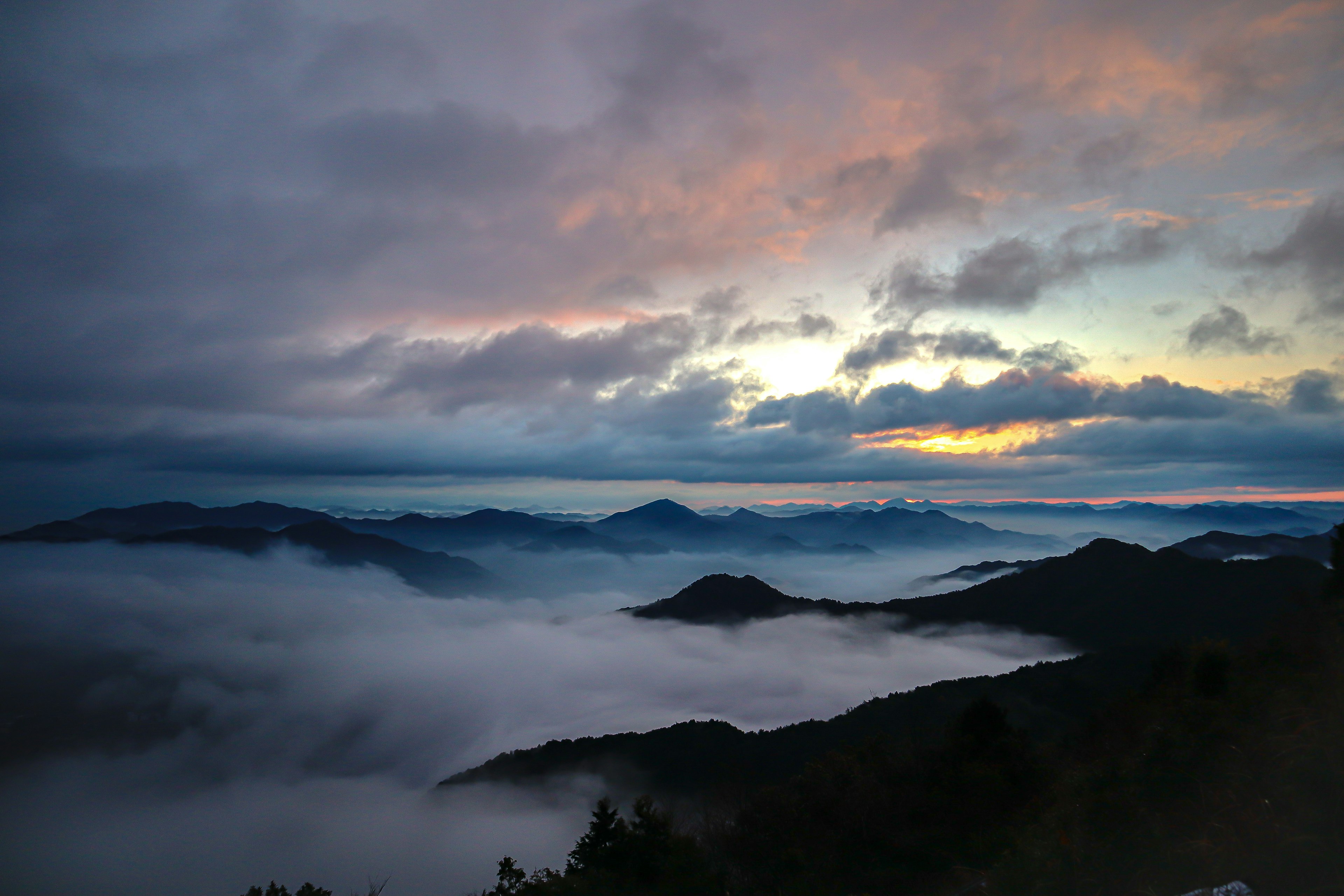 일몰에 구름으로 덮인 산의 경치