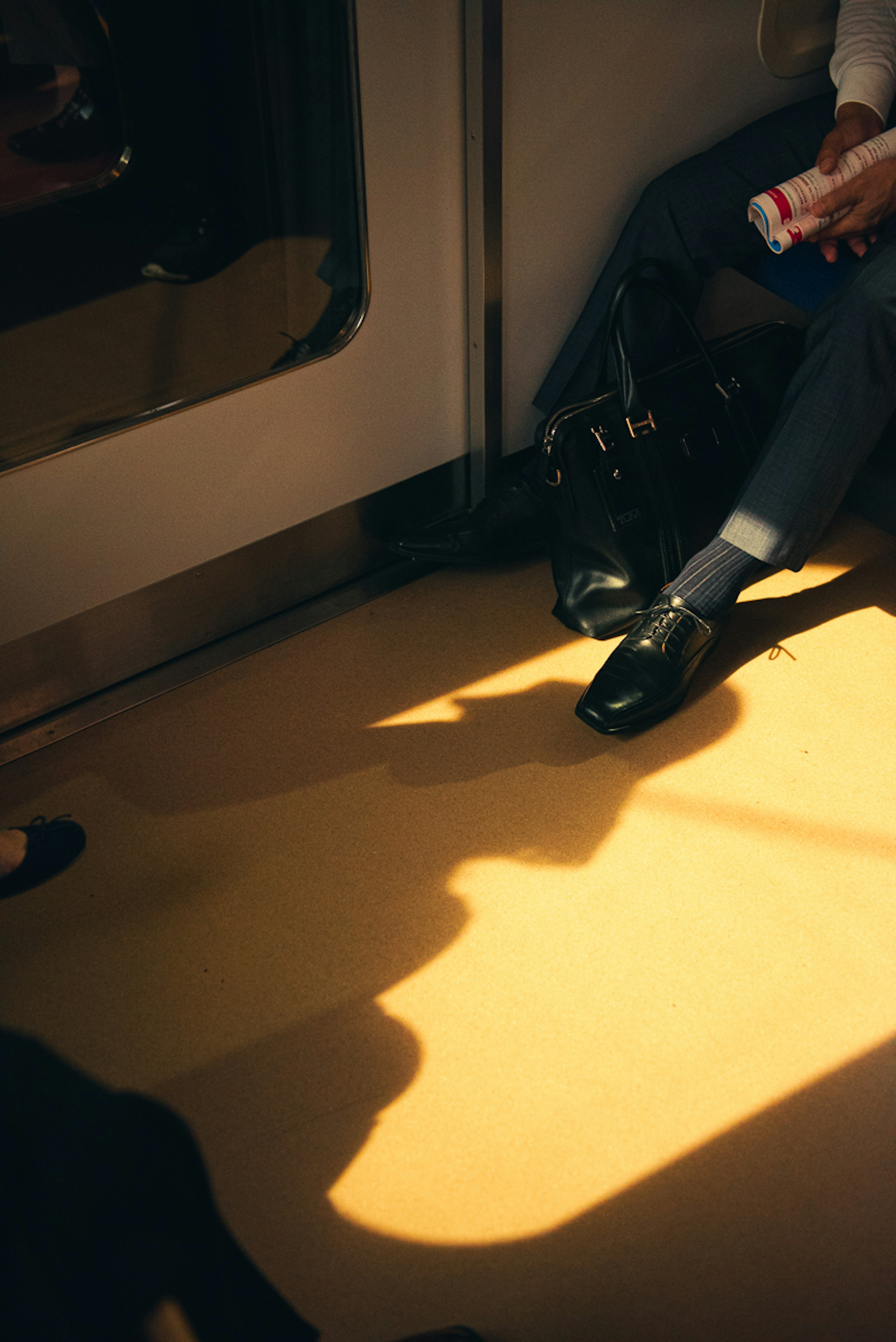 Close-up of feet and shadows inside a subway train