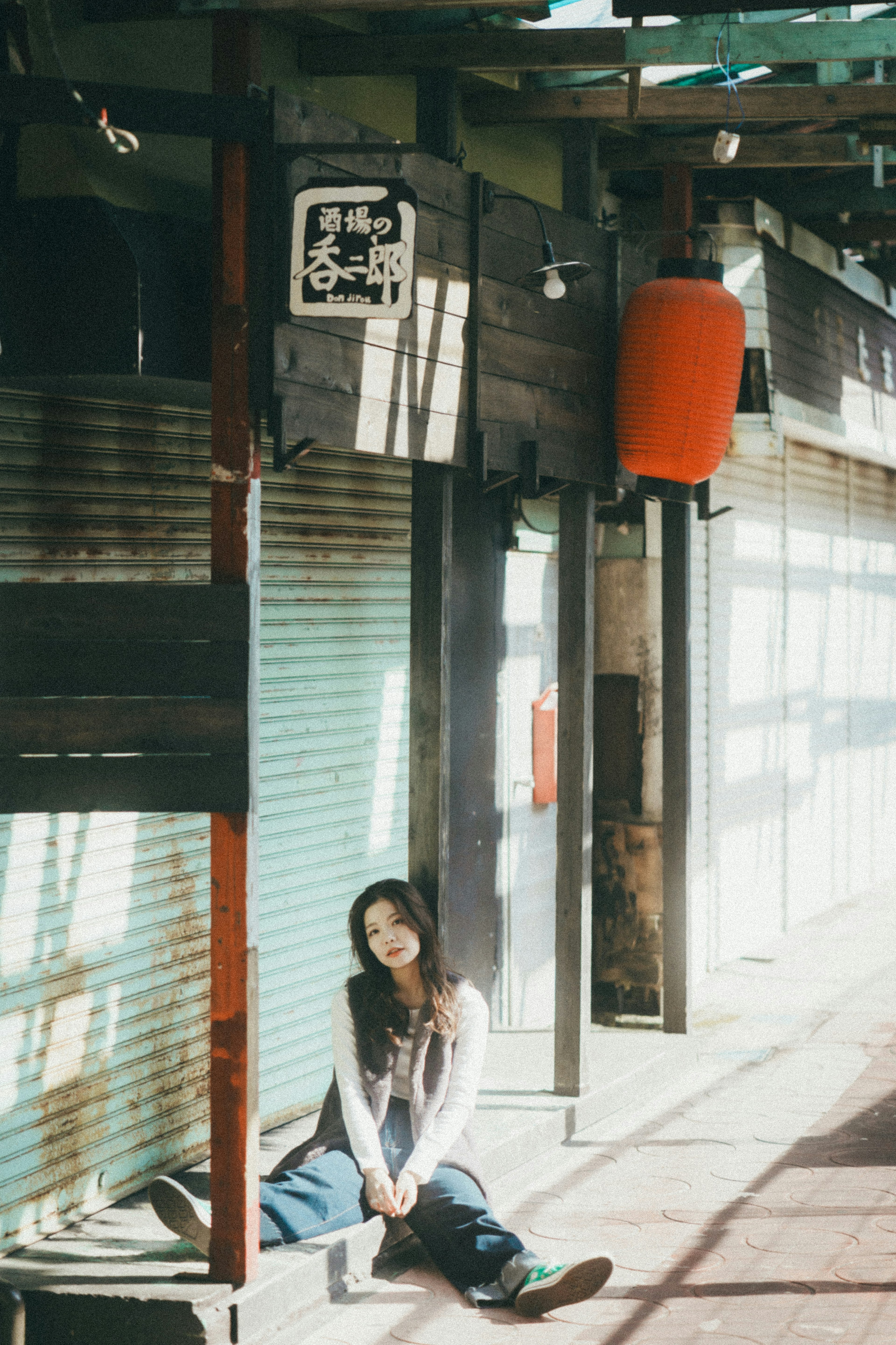 Young woman sitting in an old shopping street