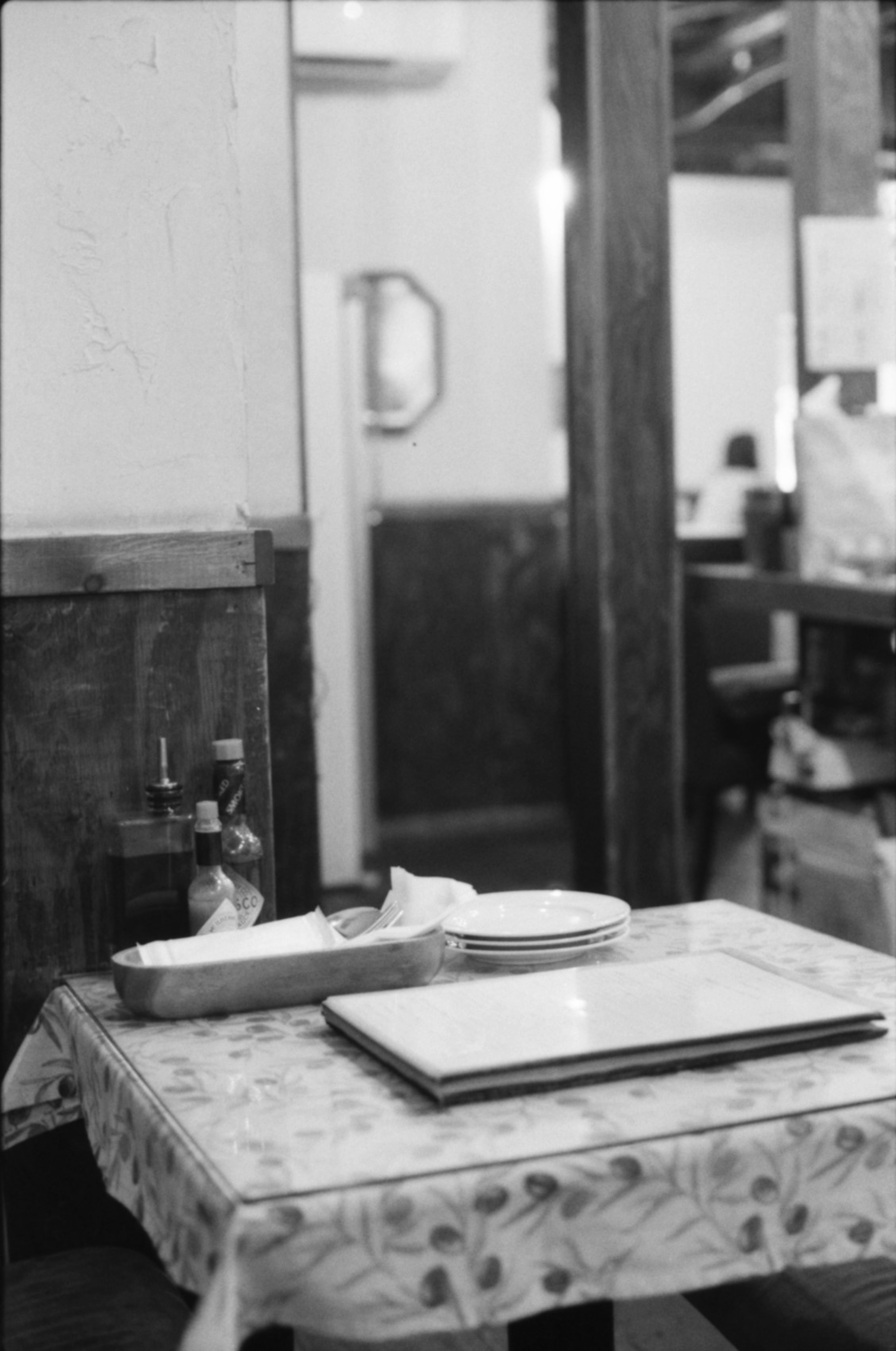 Black and white image of a restaurant table with plates and napkins