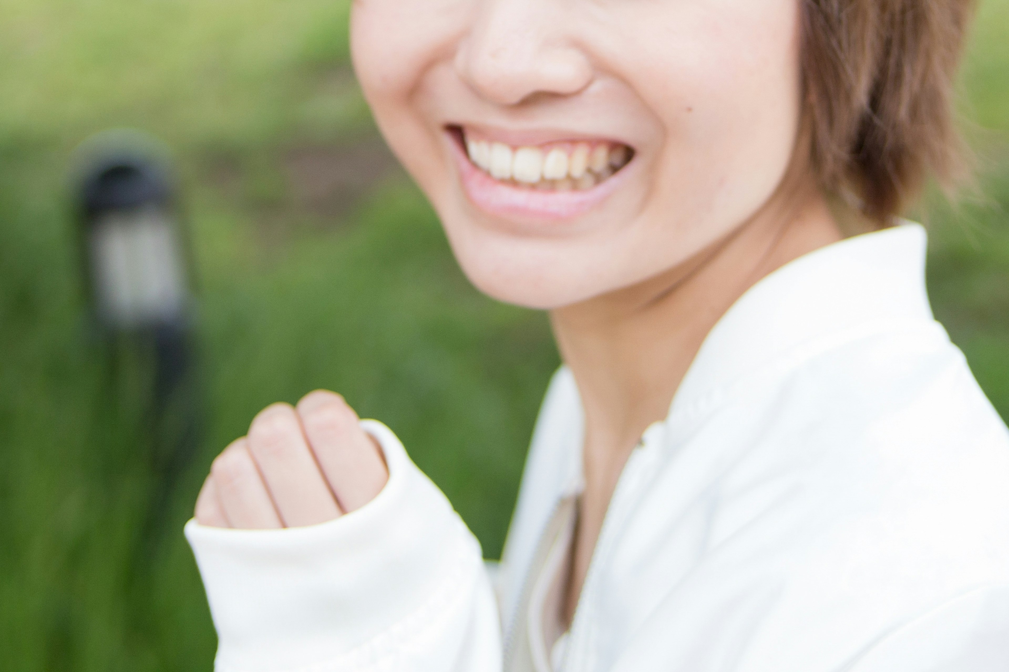 Smiling woman in white clothing with green background