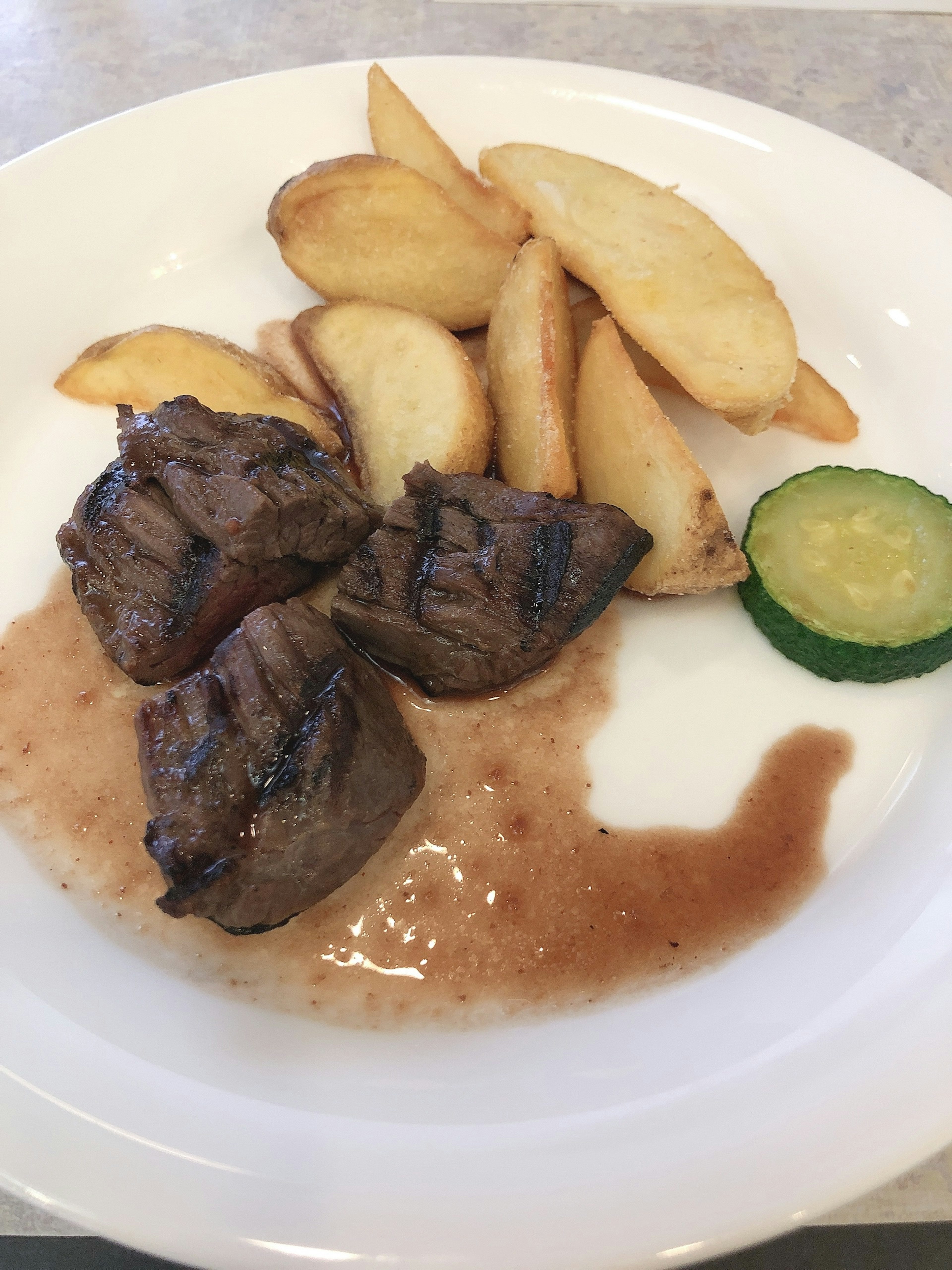 Assiette avec de la viande grillée et des quartiers de pommes de terre