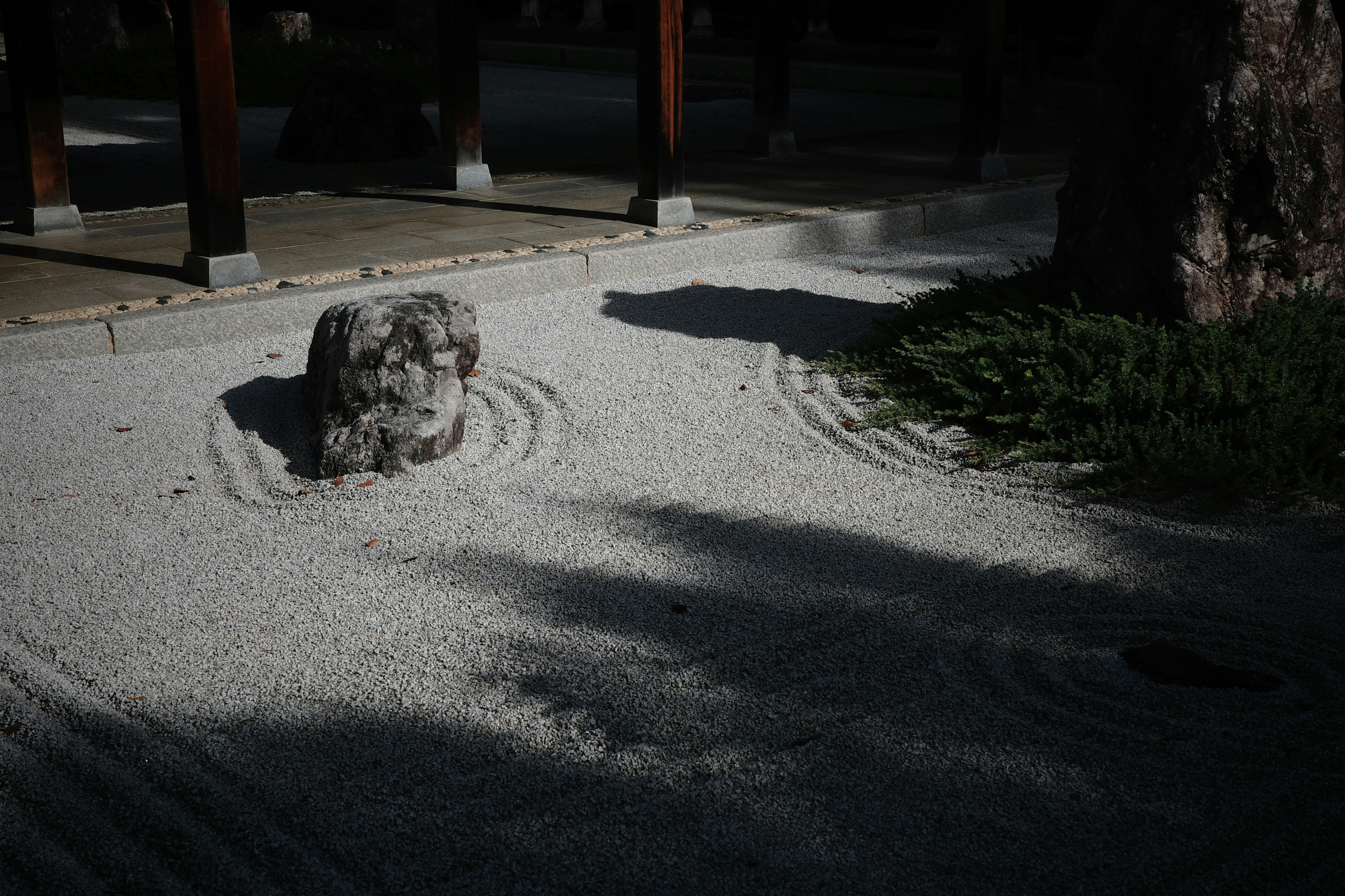 Escena de jardín sereno con arena blanca y una piedra