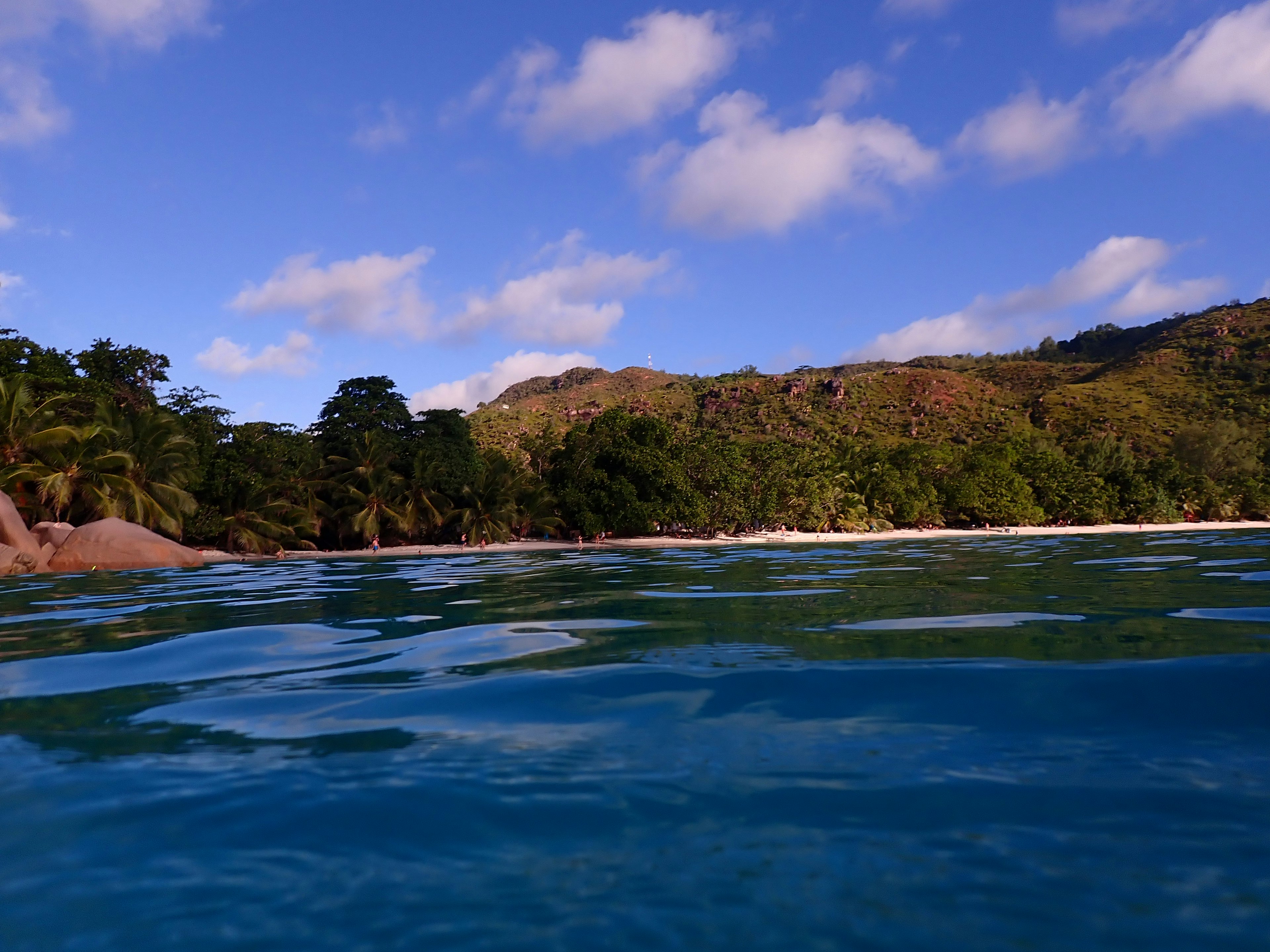 Scenic view of blue ocean with green hills in the background