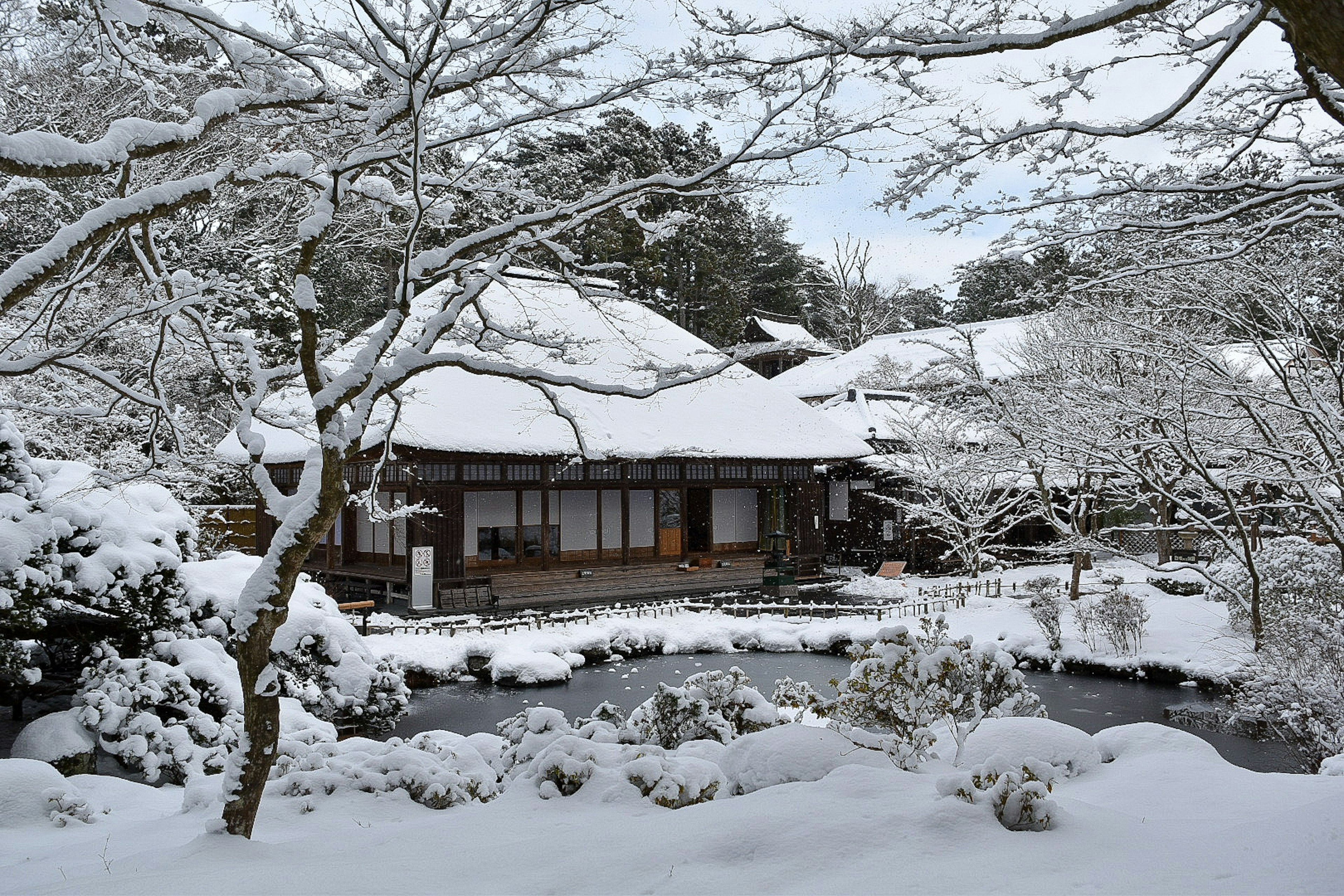 雪に覆われた日本の伝統的な家屋と庭