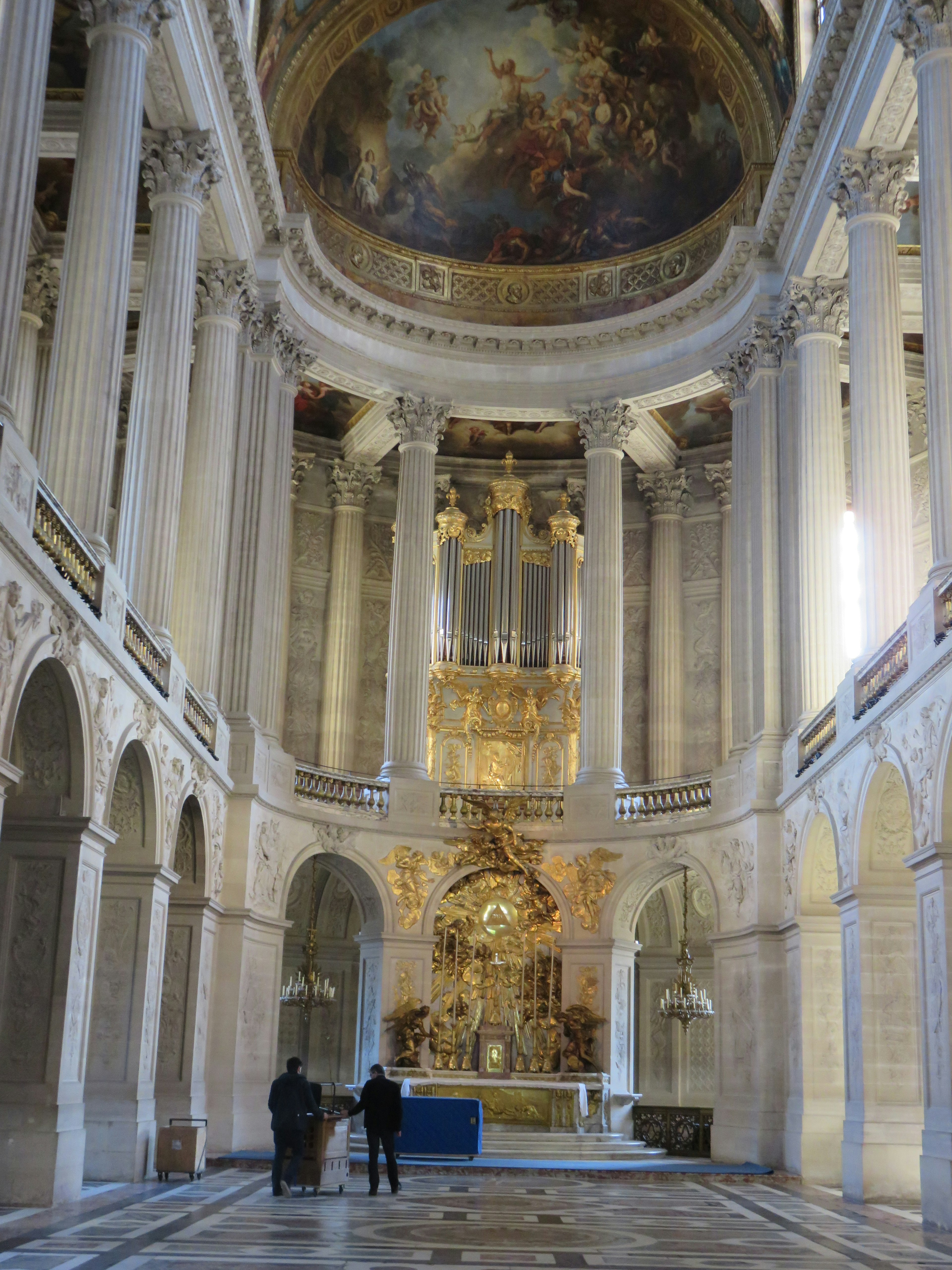 Grand interior of the Palace of Versailles featuring ornate decorations and marble columns