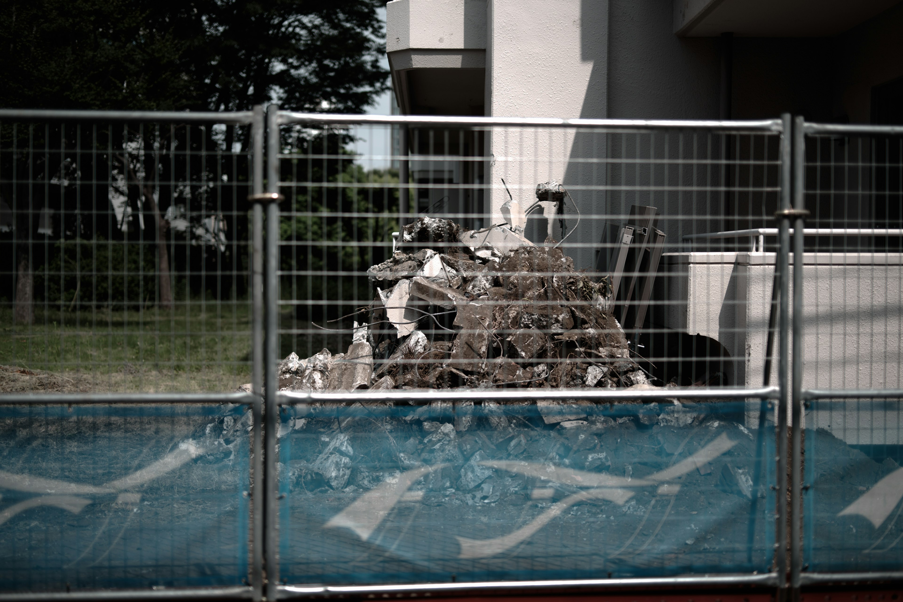 Piled debris within a fenced area near a building