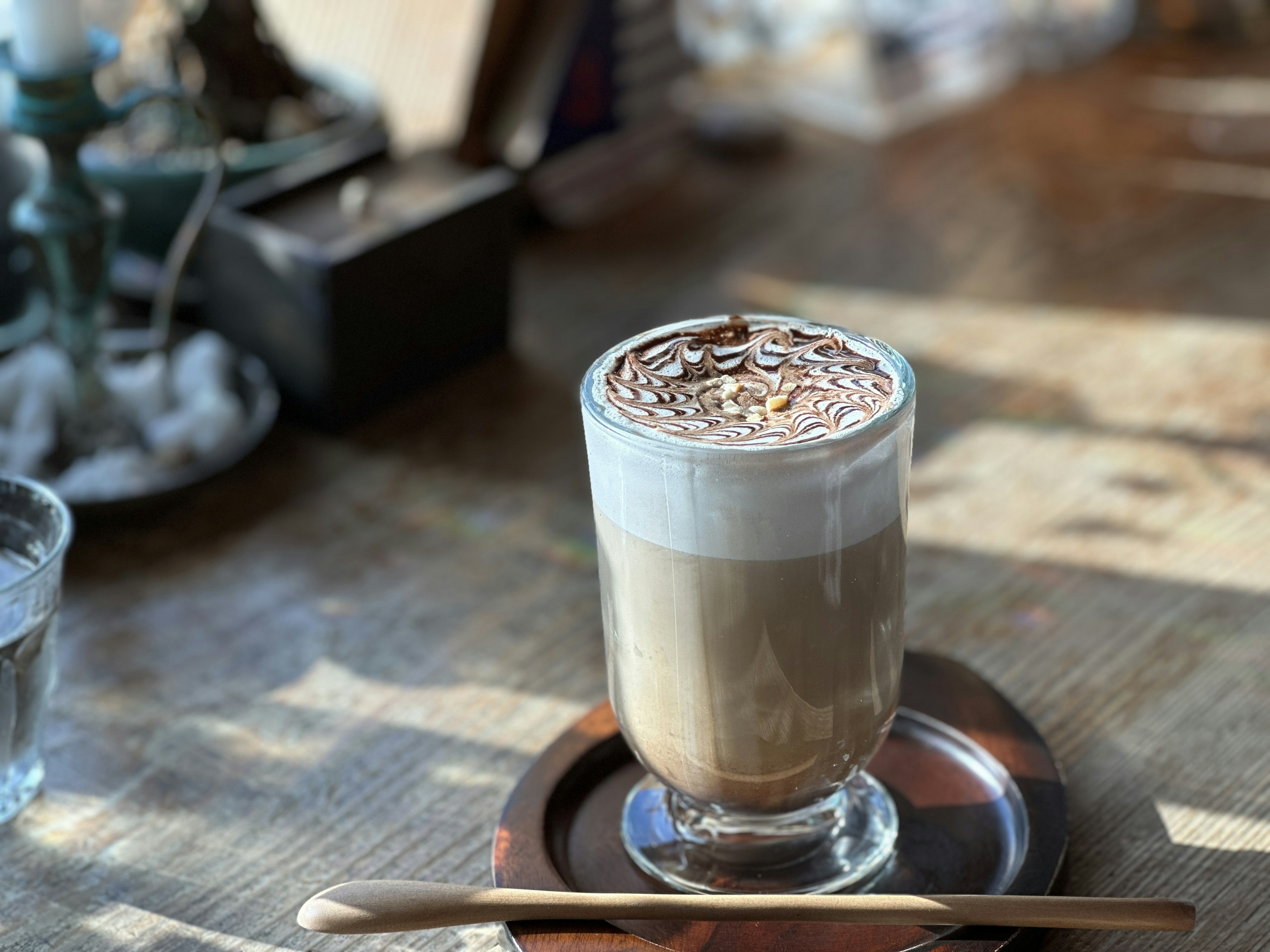 Un bicchiere di caffè con uno strato cremoso guarnito con scaglie di cioccolato