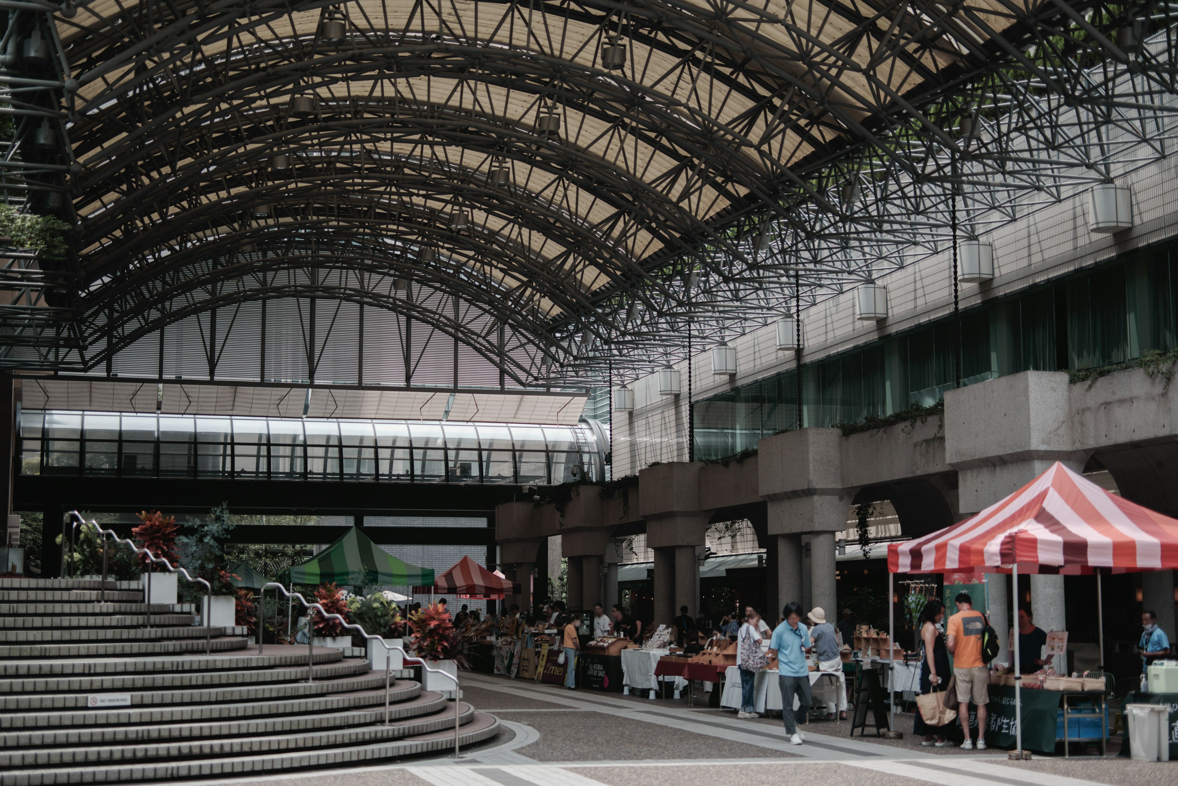 Spacious indoor market scene with red and white striped tents