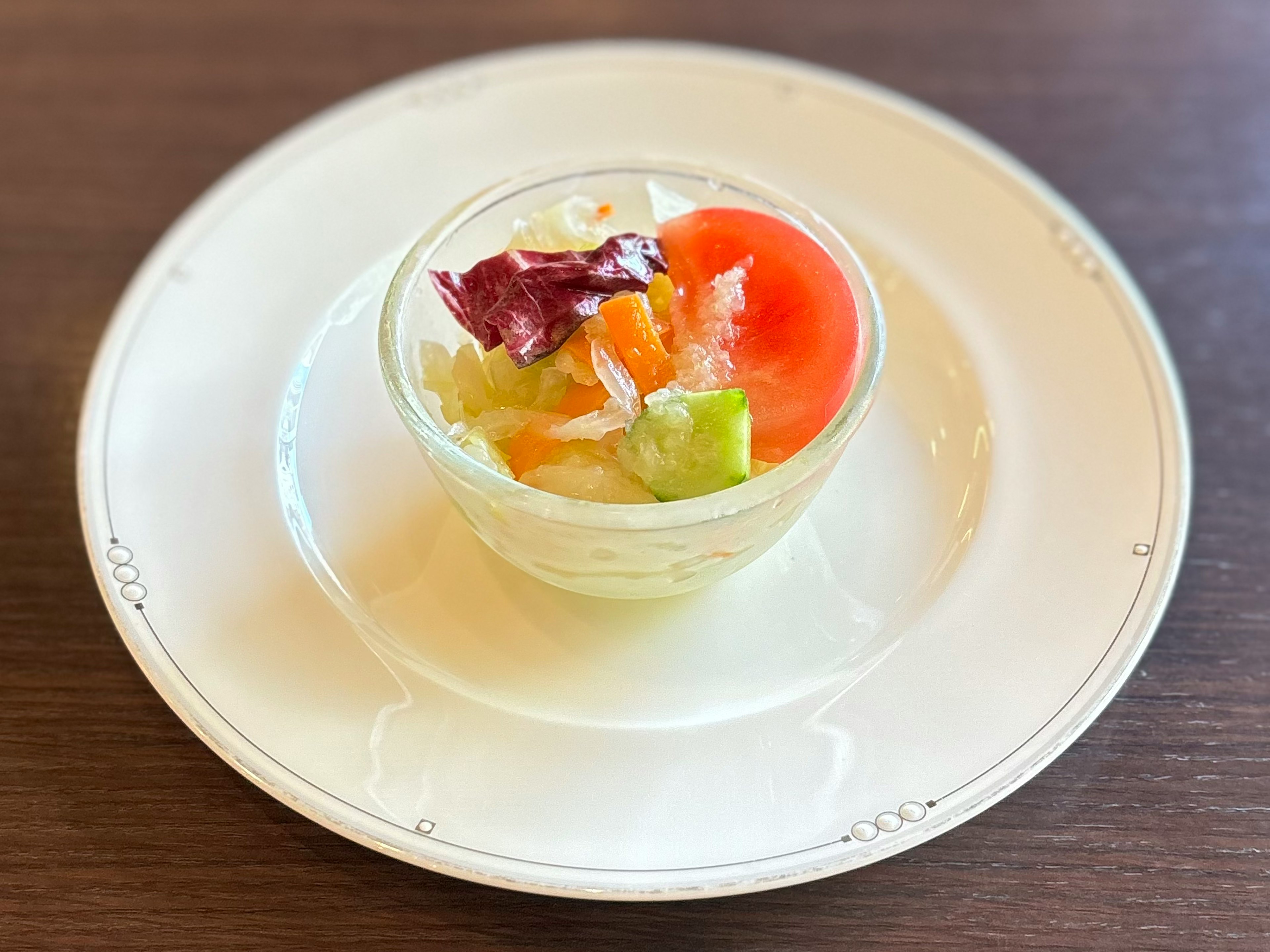 Ensalada fresca de verduras y frutas servida en un tazón transparente