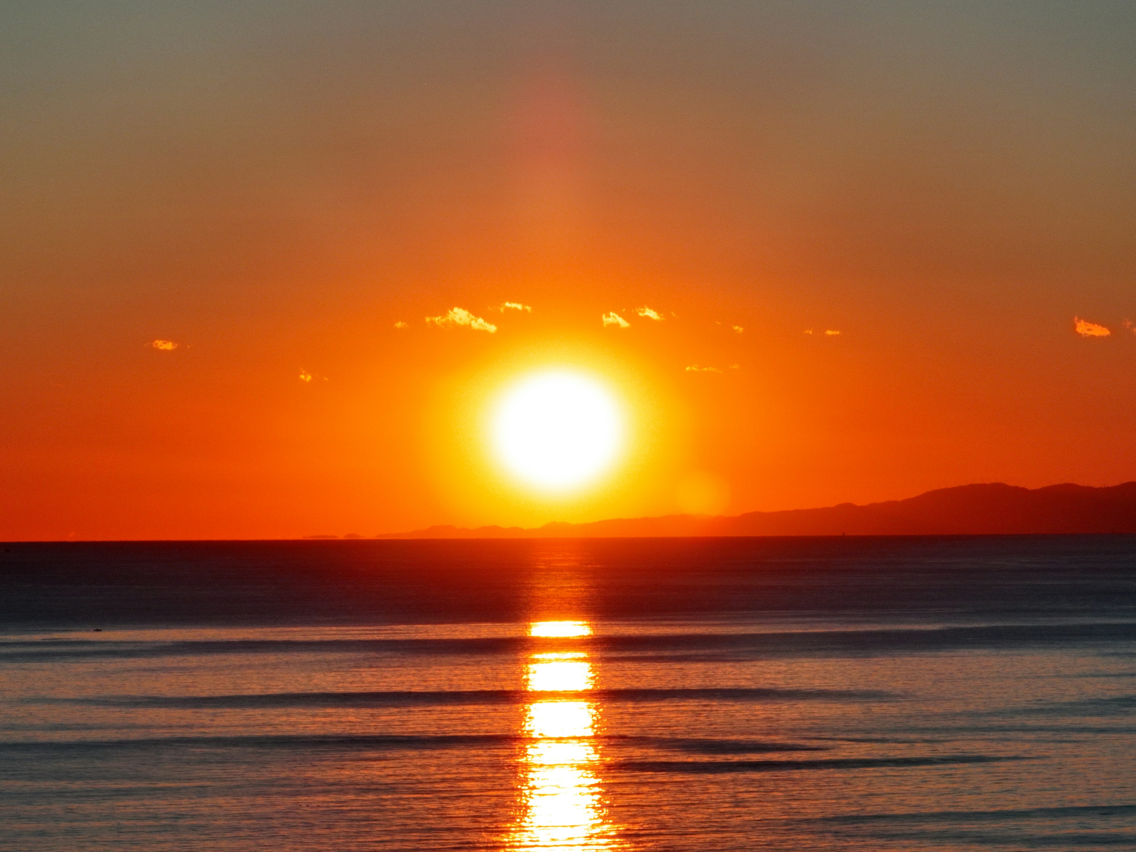 Ein schöner Sonnenuntergang über dem Ozean mit lebhaften Orangetönen