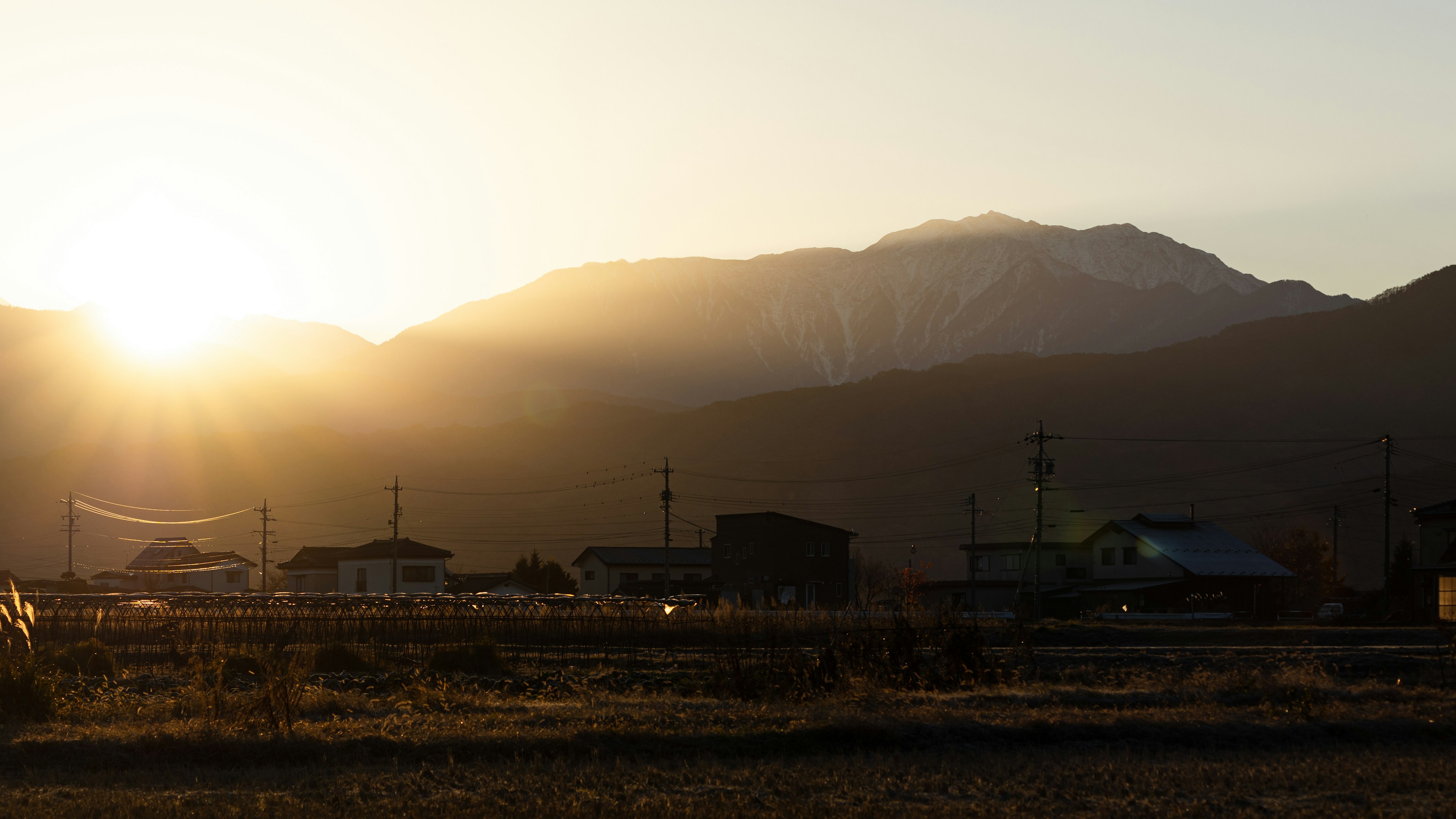 Coucher de soleil sur les montagnes avec des maisons rurales