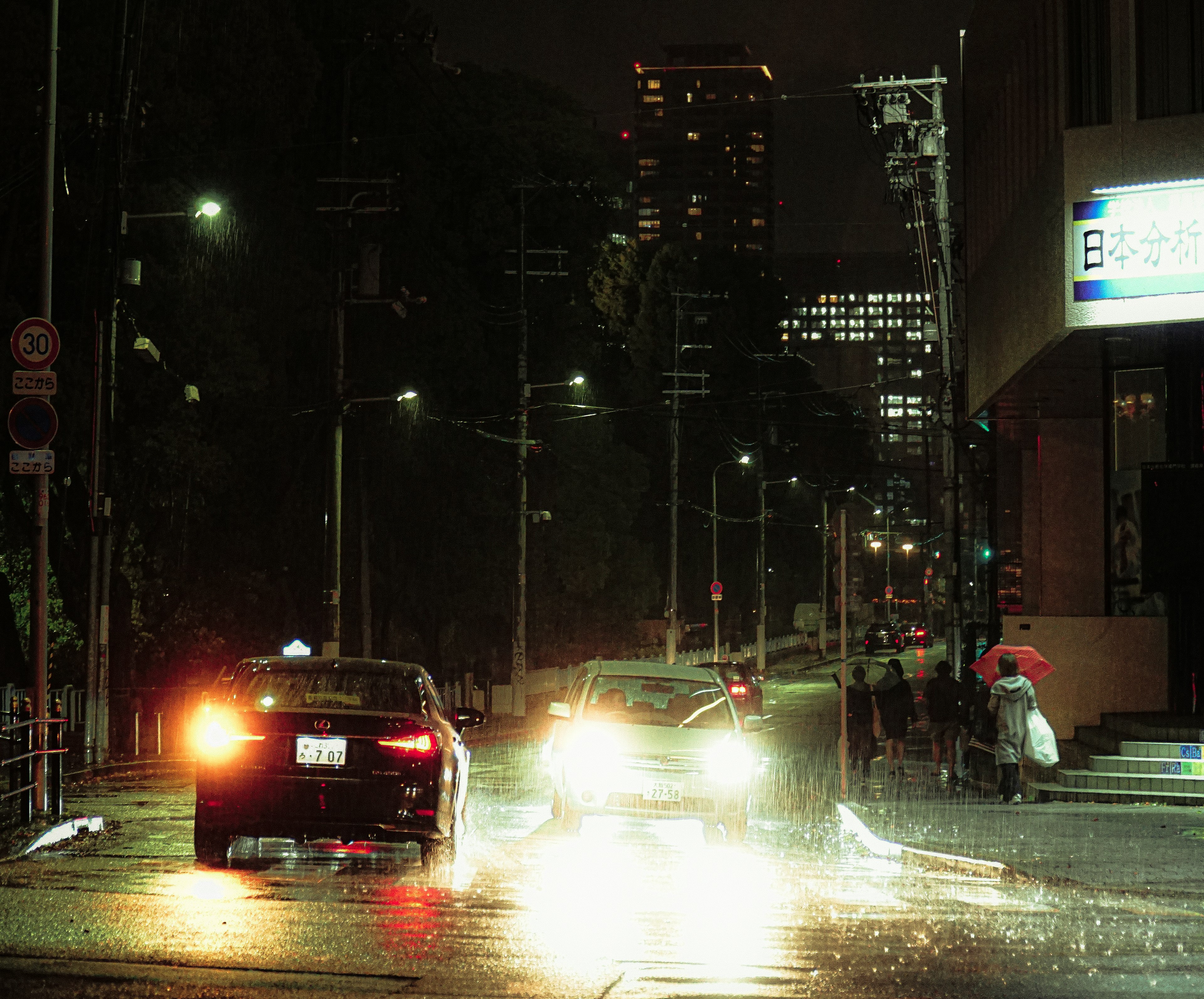 Faros de taxi y coche en una calle de ciudad lluviosa por la noche