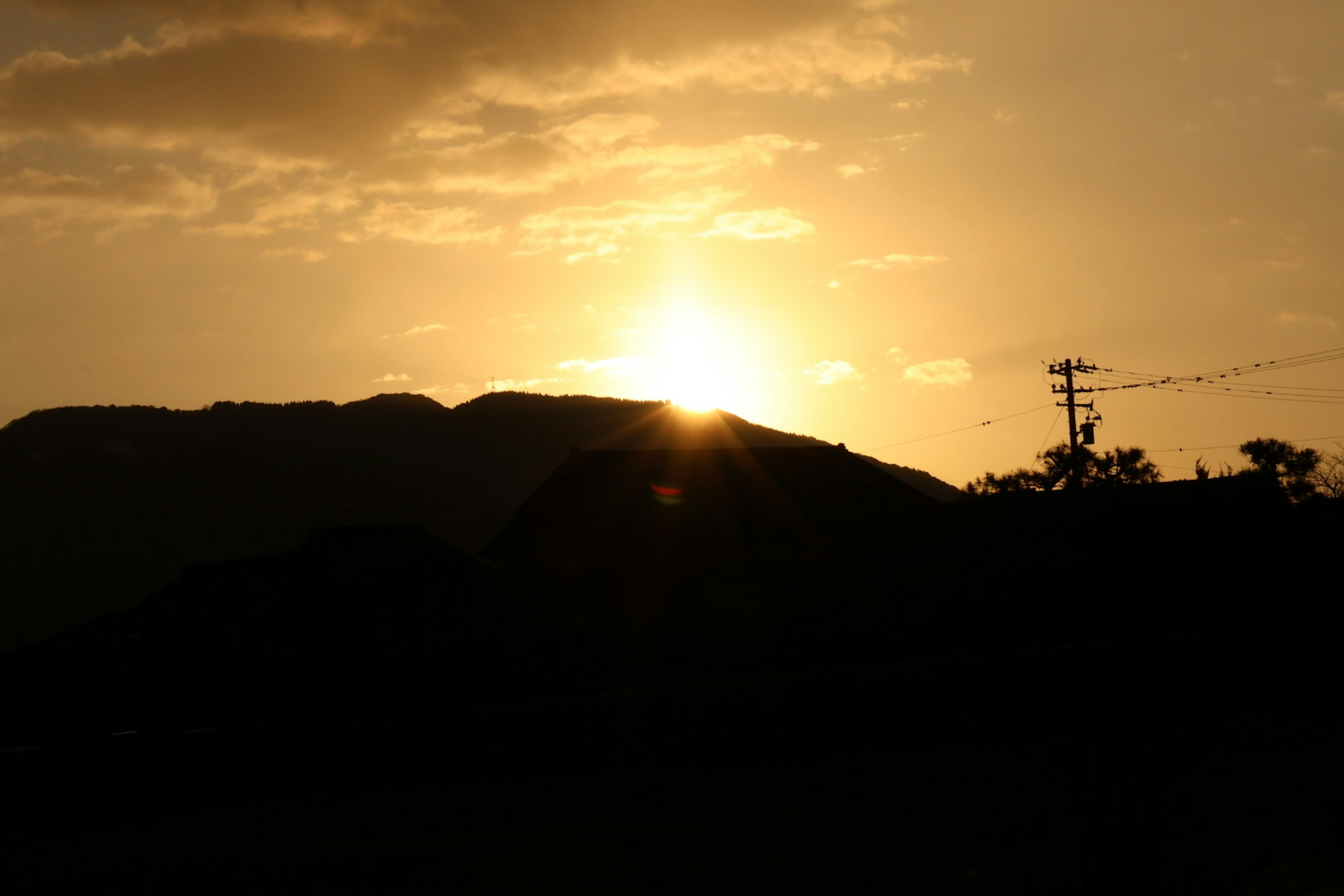 Sunset over a mountain silhouette with an orange sky