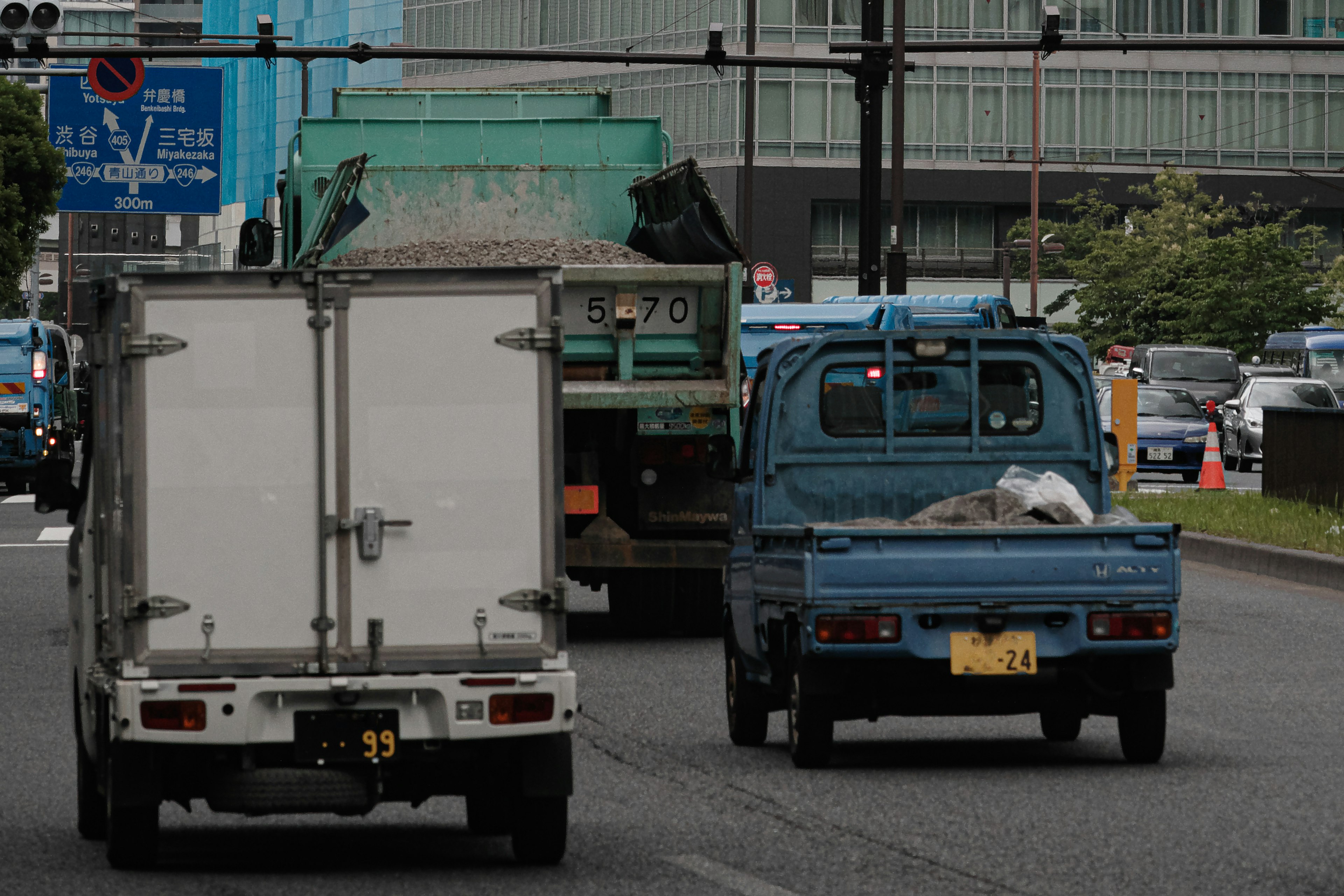 Trucks and a small vehicle traveling on an urban road