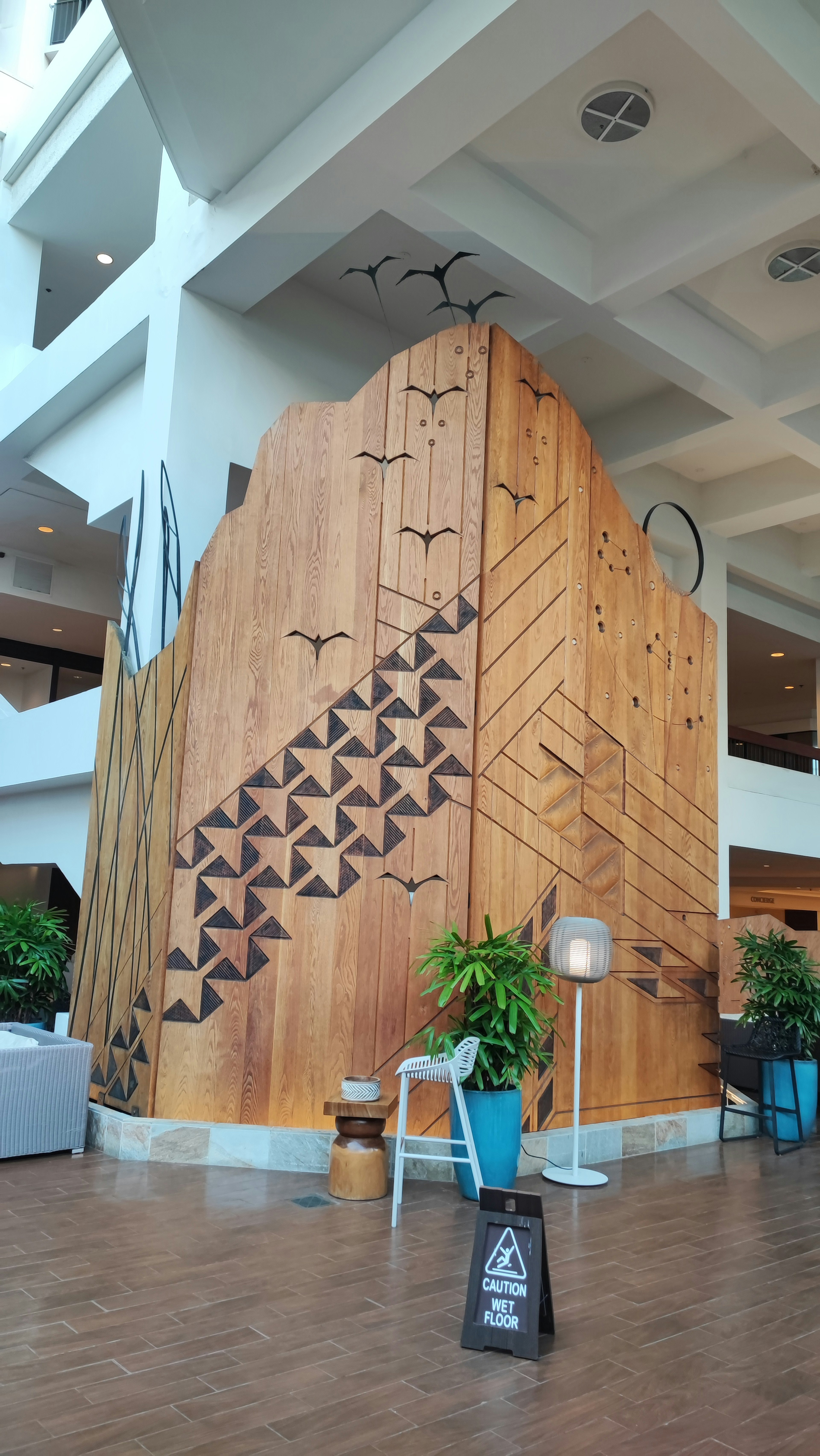 Vestíbulo de hotel con pared de madera y diseños triangulares