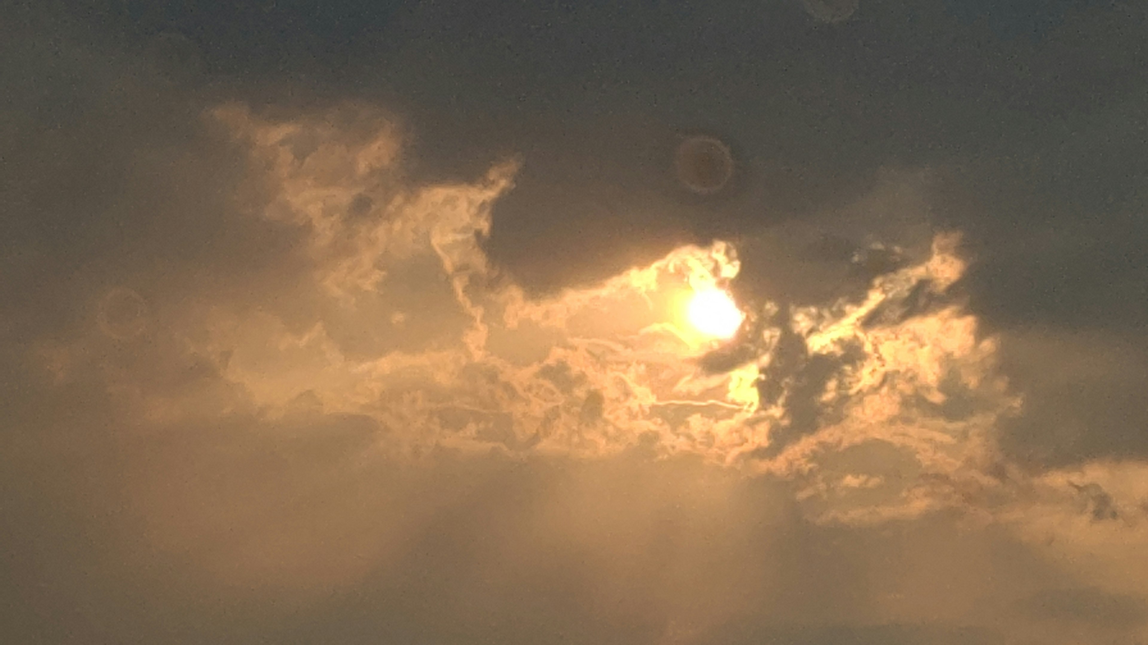 Sunlight peeking through dark clouds with a dramatic sky