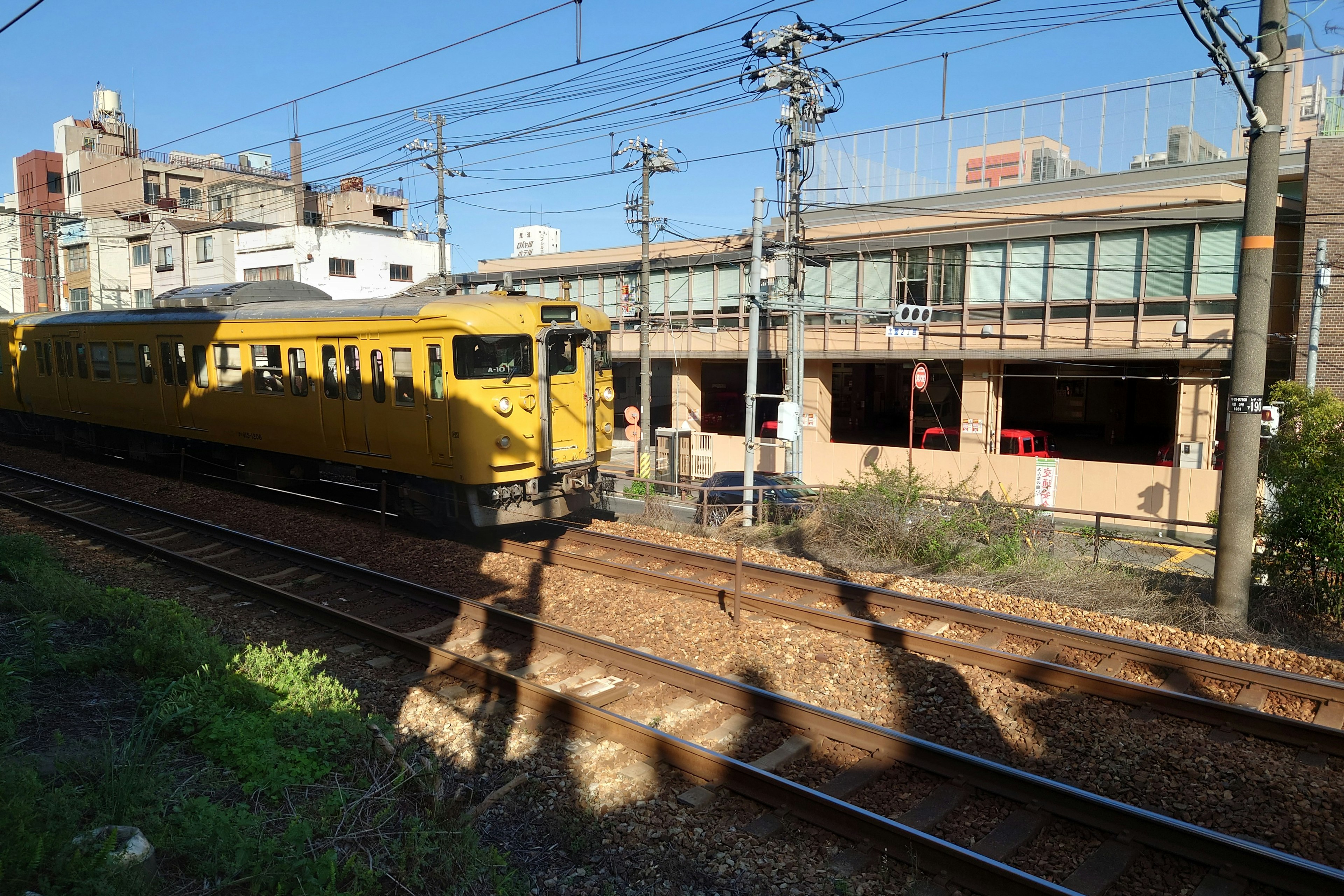 黄色い電車が駅の近くを走っている風景