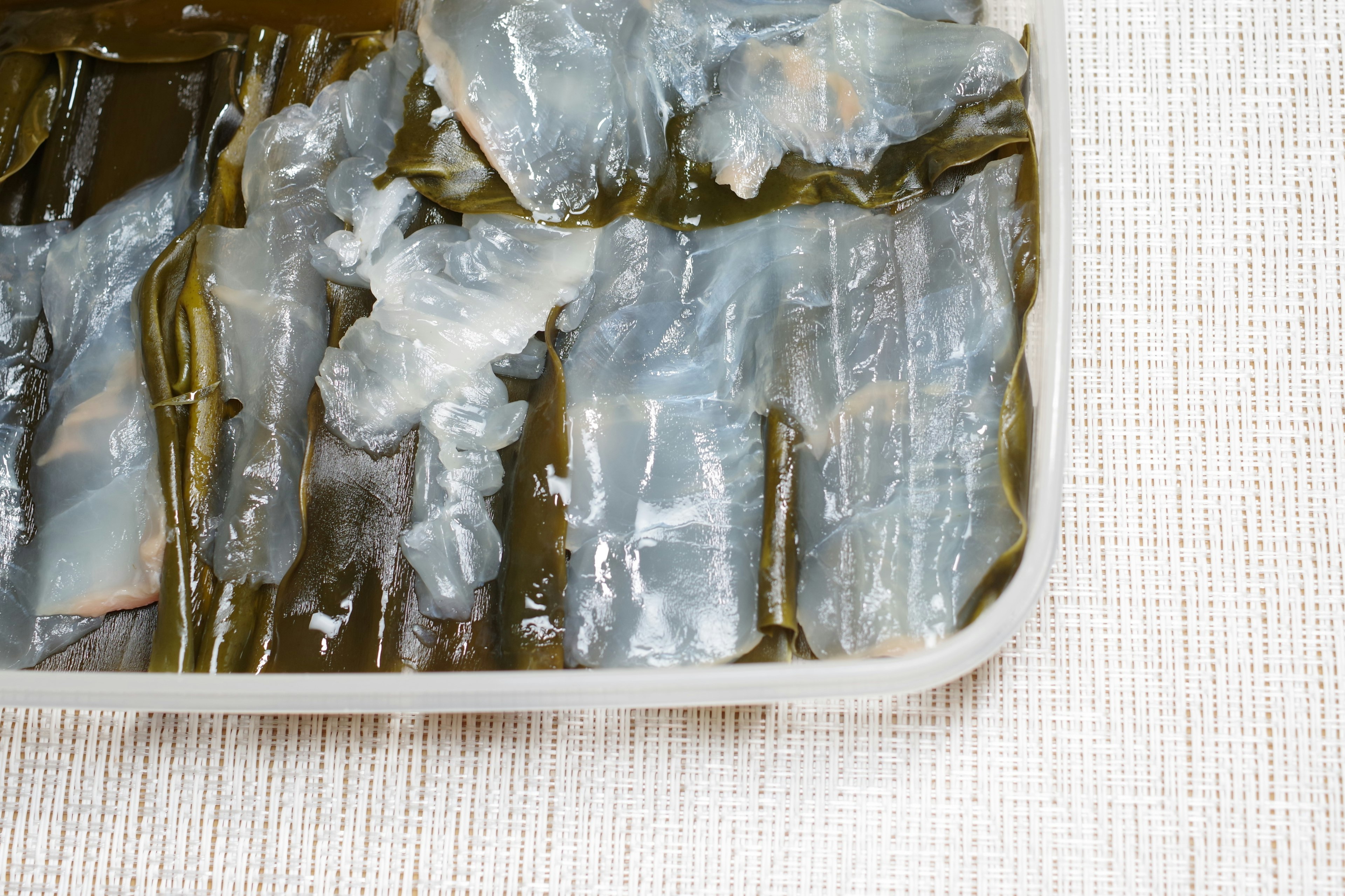 Sliced cold fish arranged with translucent seaweed