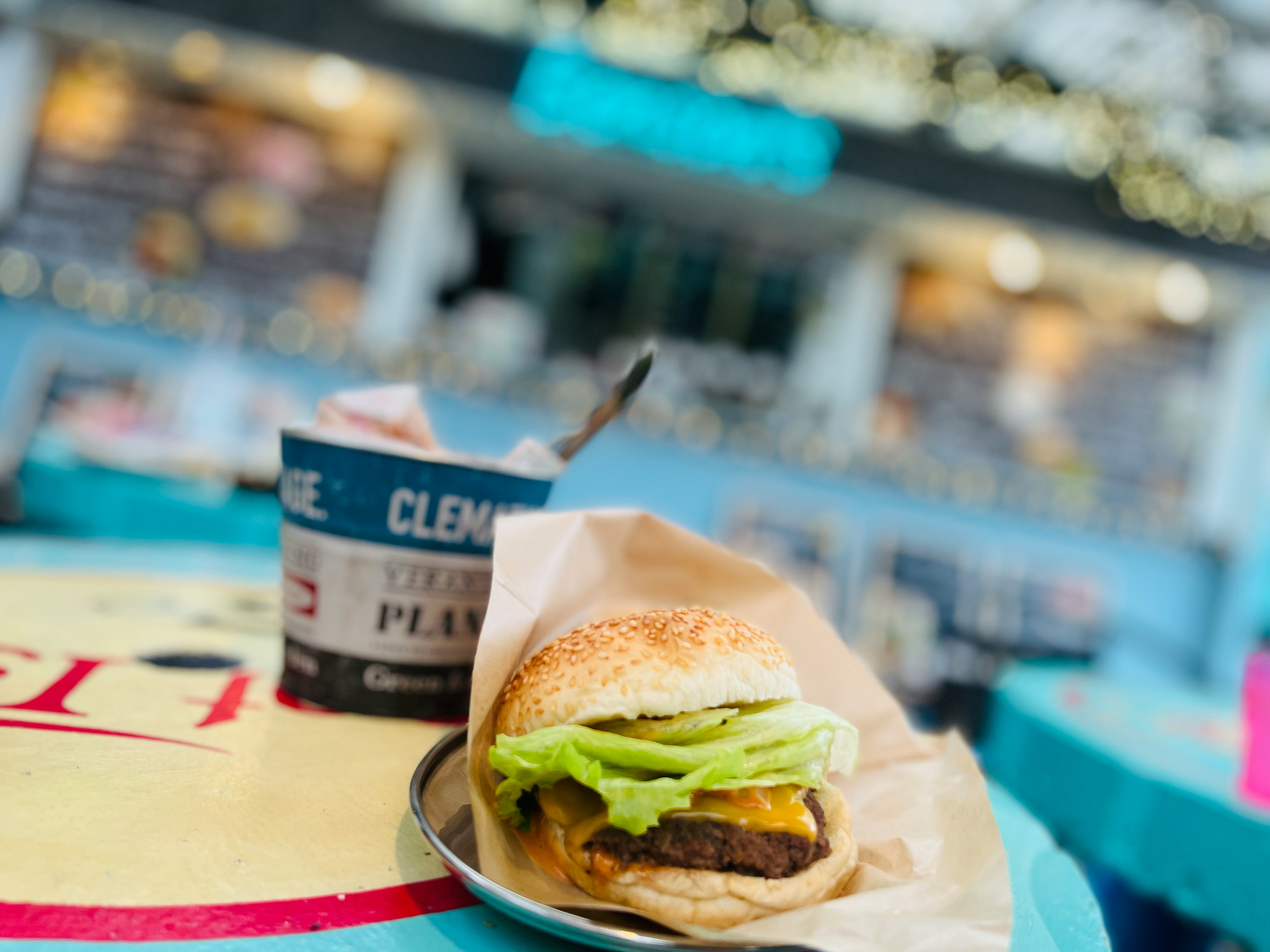 美味しそうなハンバーガーとサイドの容器があるカフェの風景