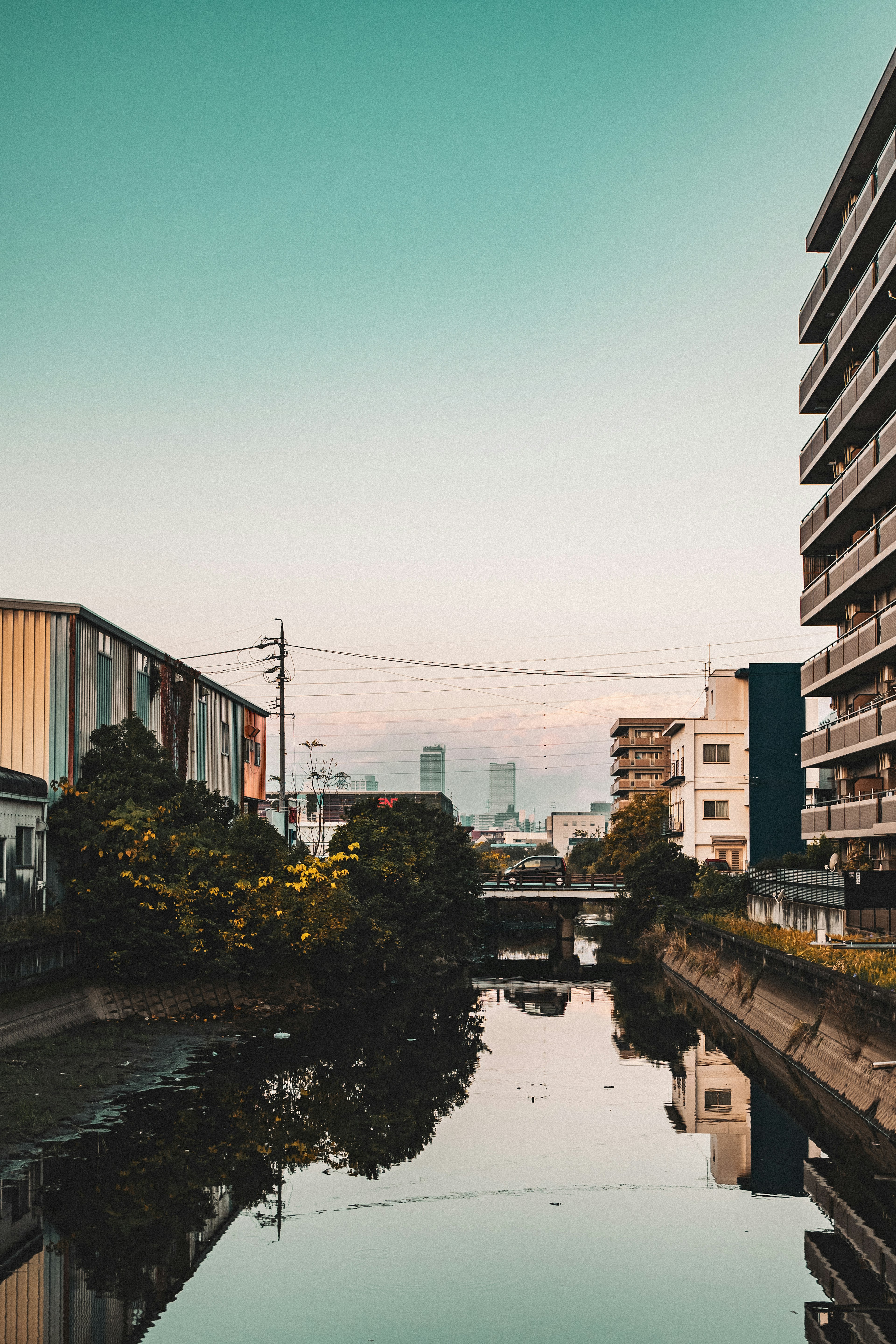 城市風景，有寧靜的河流和附近建築，藍天