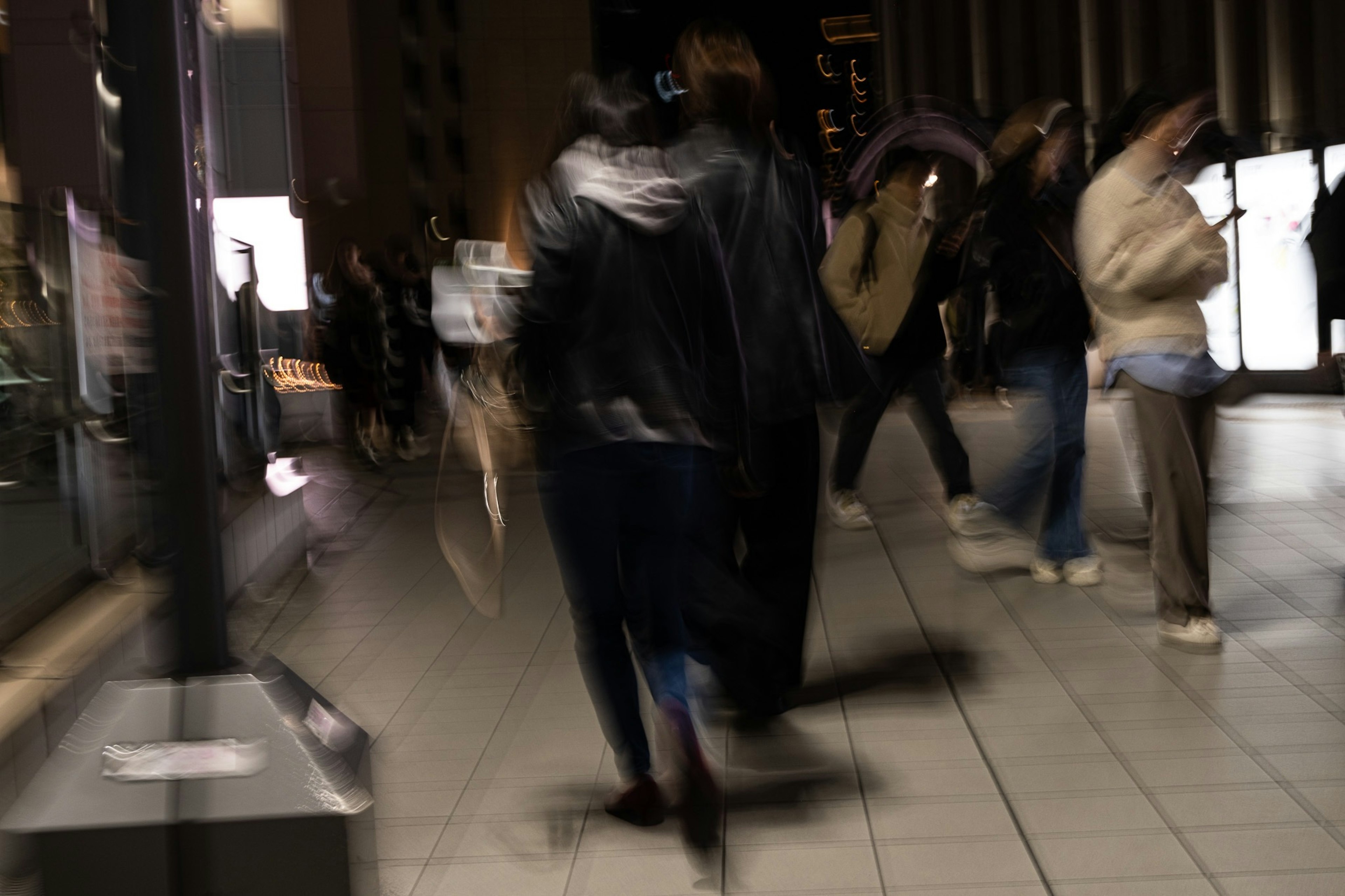 Figures floues de personnes marchant dans une ville nocturne