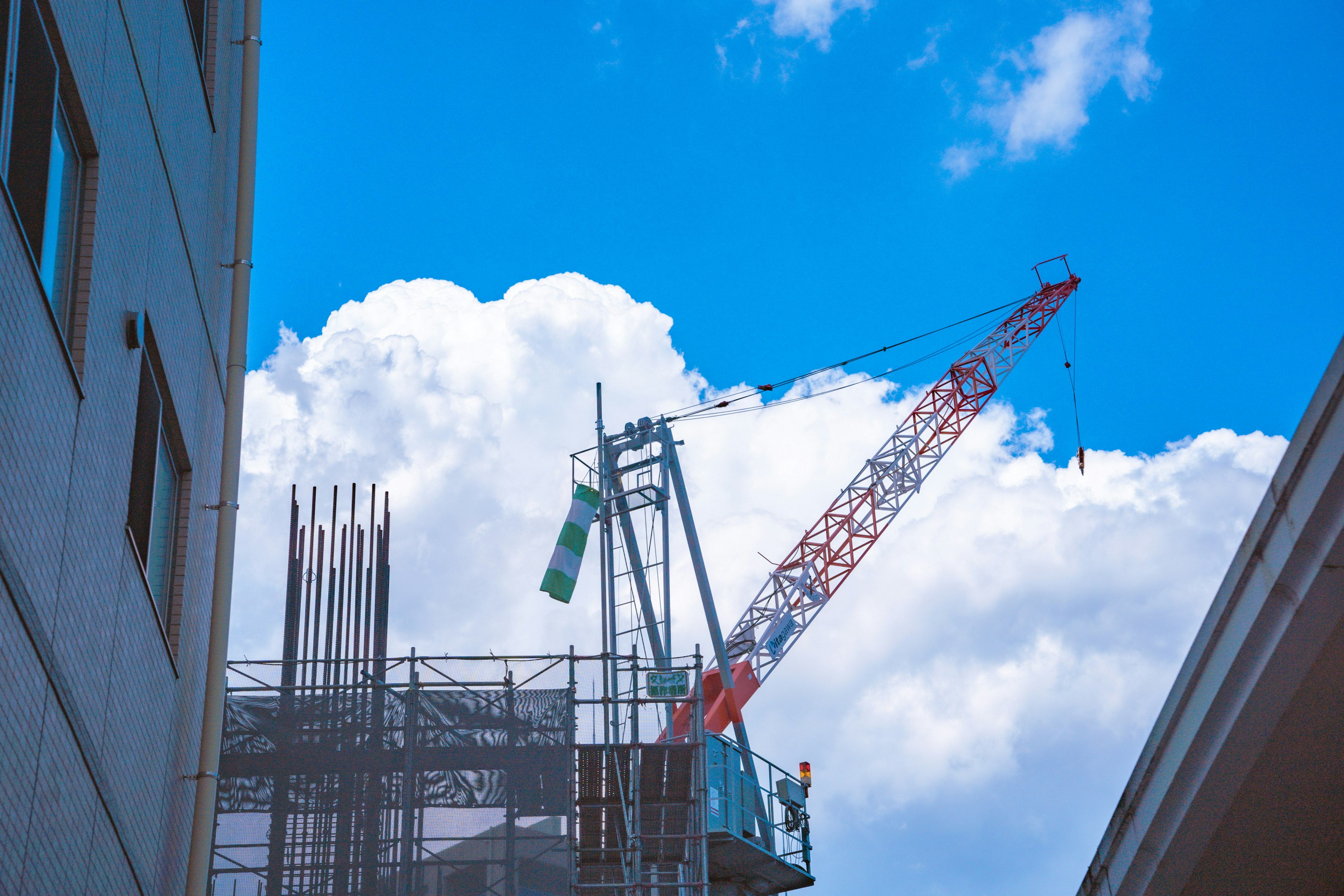 Chantier de construction avec grue et structure de bâtiment sous un ciel bleu