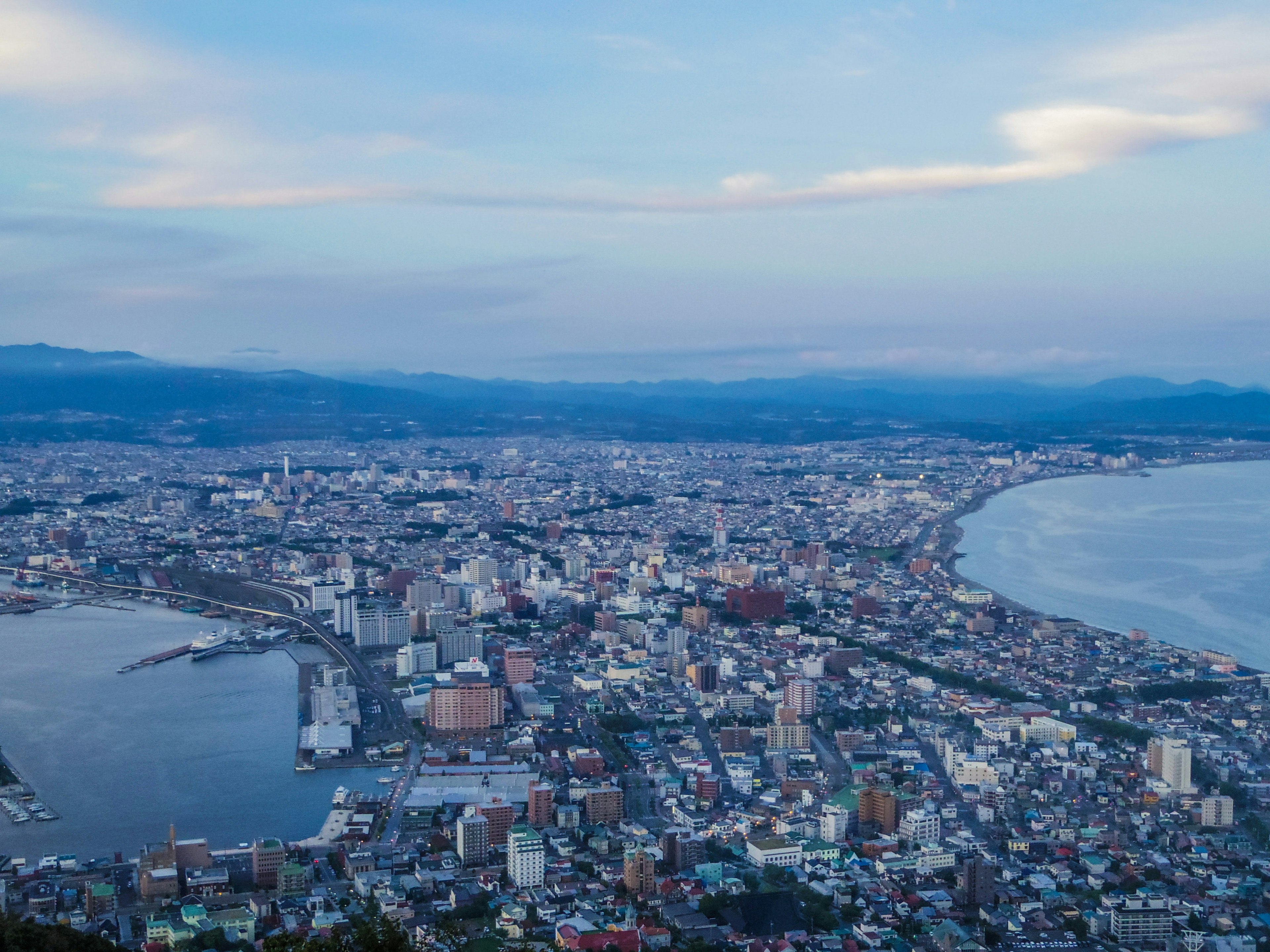 Luftaufnahme der Stadt Hakodate mit Küste und Bergen